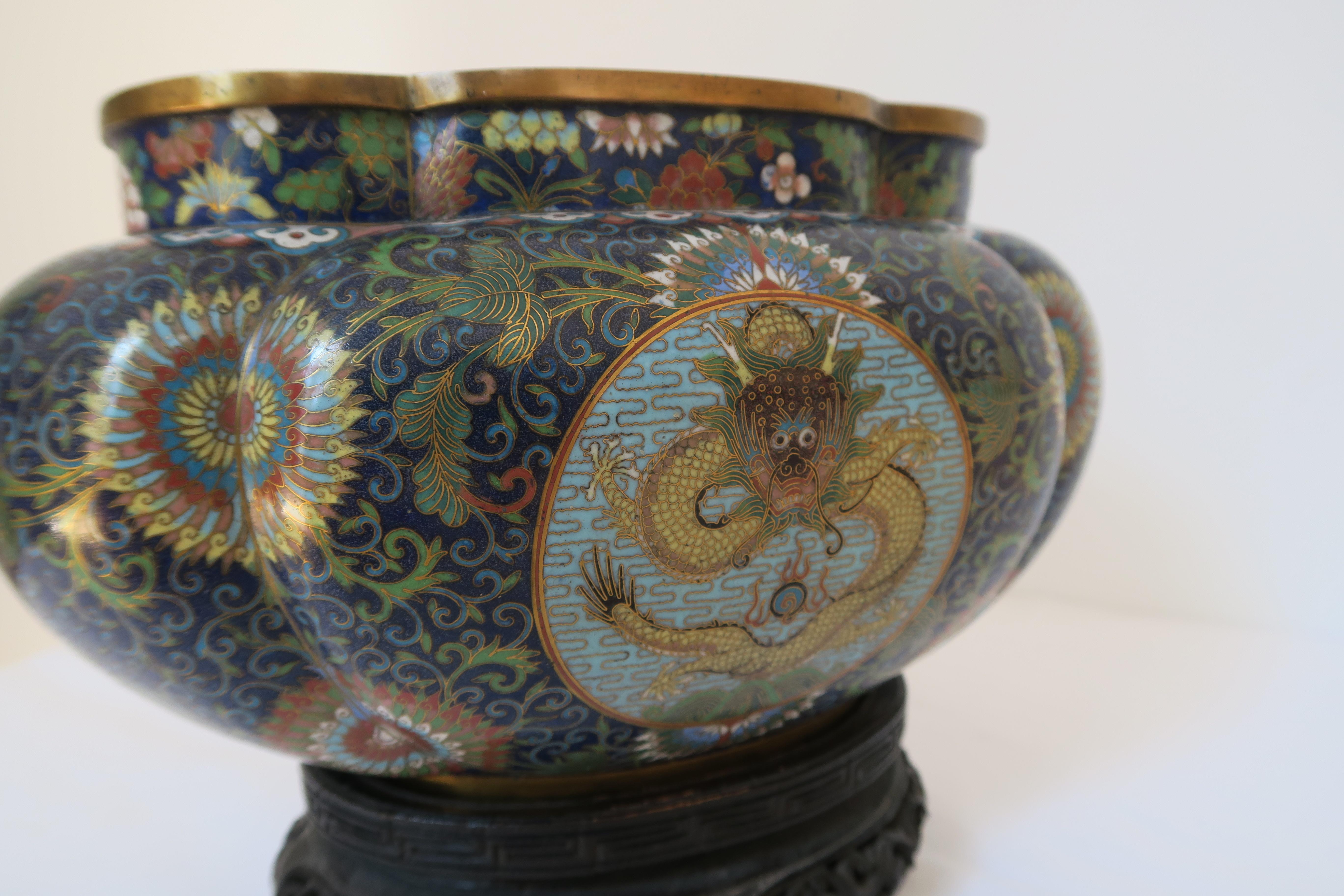 Chinese enamel Cloisonné vase, bowl, jardinere, featuring a dragon depiction from Jiaqing-Period with wooden stand. Both items in excellent condition with no dents or scratches.

Measures: total height 29.5 cm.
Width 26 cm.
Total depth 8.5cm.