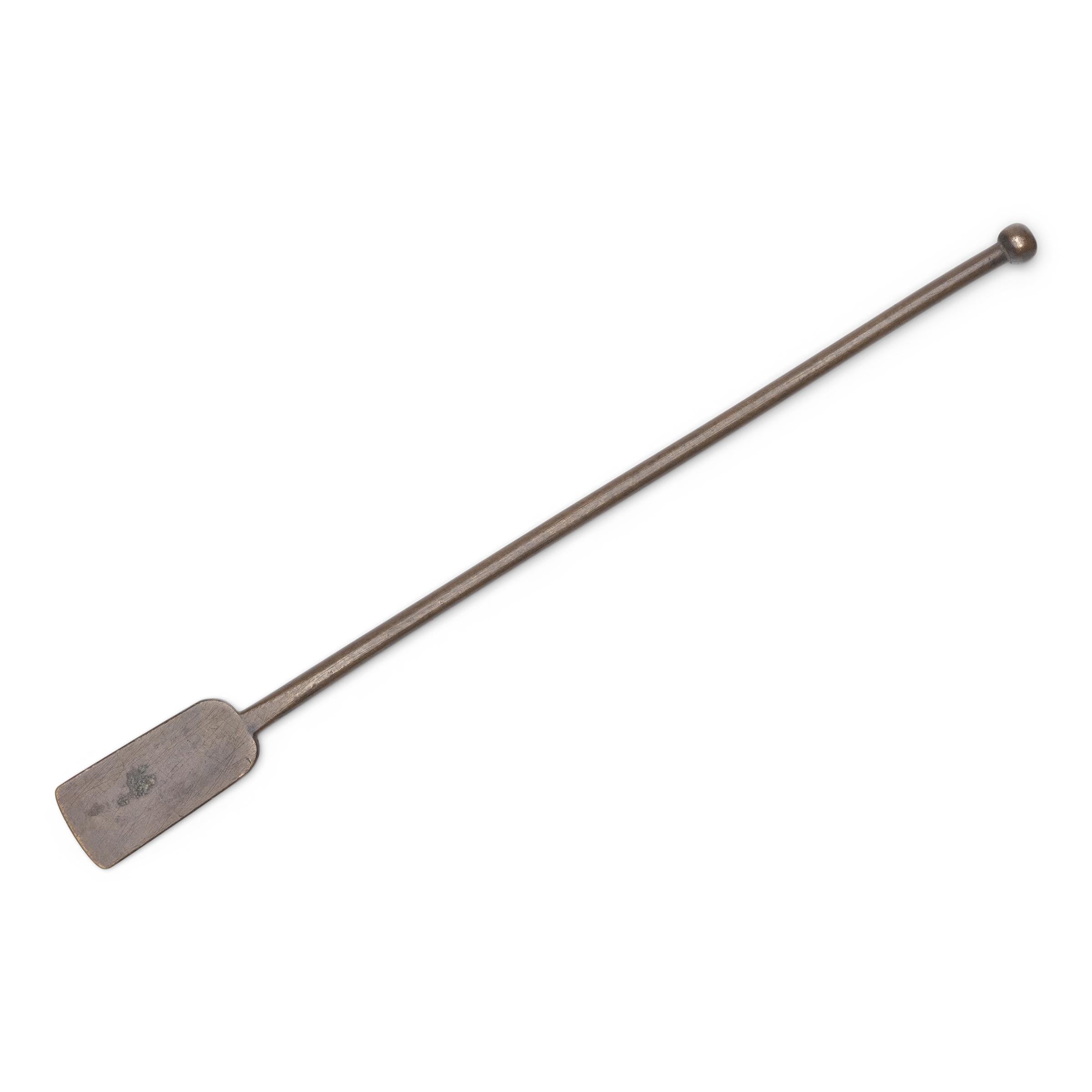 Cet élégant outil en bronze date de la fin du XIXe siècle et était à l'origine l'un des nombreux accessoires composant un kit de fumeur d'opium. L'outil, qui ressemble à une pelle, se termine par une palette plate et rectangulaire, utilisée