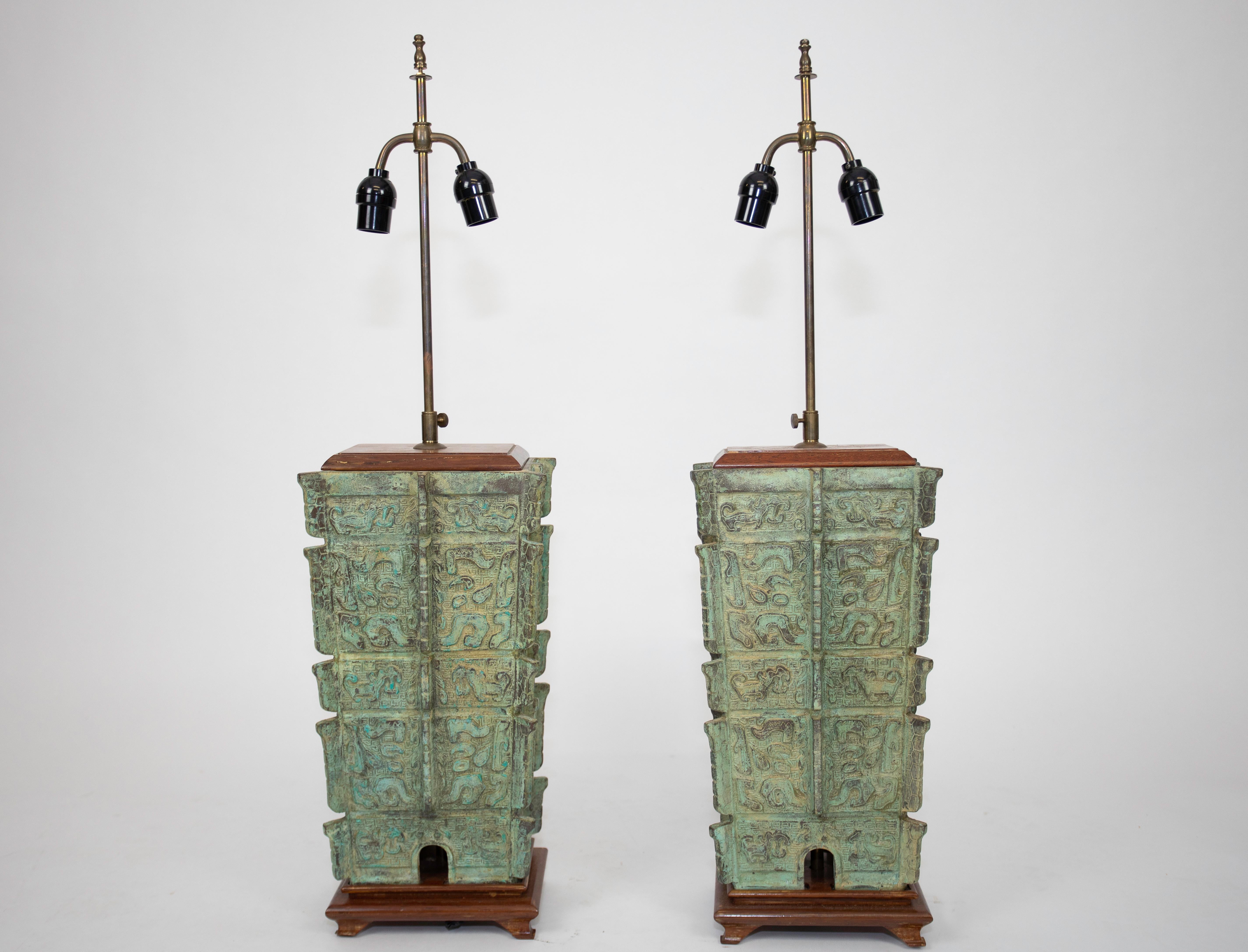 A pair of midcentury Chinese modern lamps made from Bronze with wood base.
Similar pair of lamps were features in Architectural Digest showing Jennifer Aniston's home (see photo).
Excellent Verdi Gris patina 
Original shades
Re-wired.
  