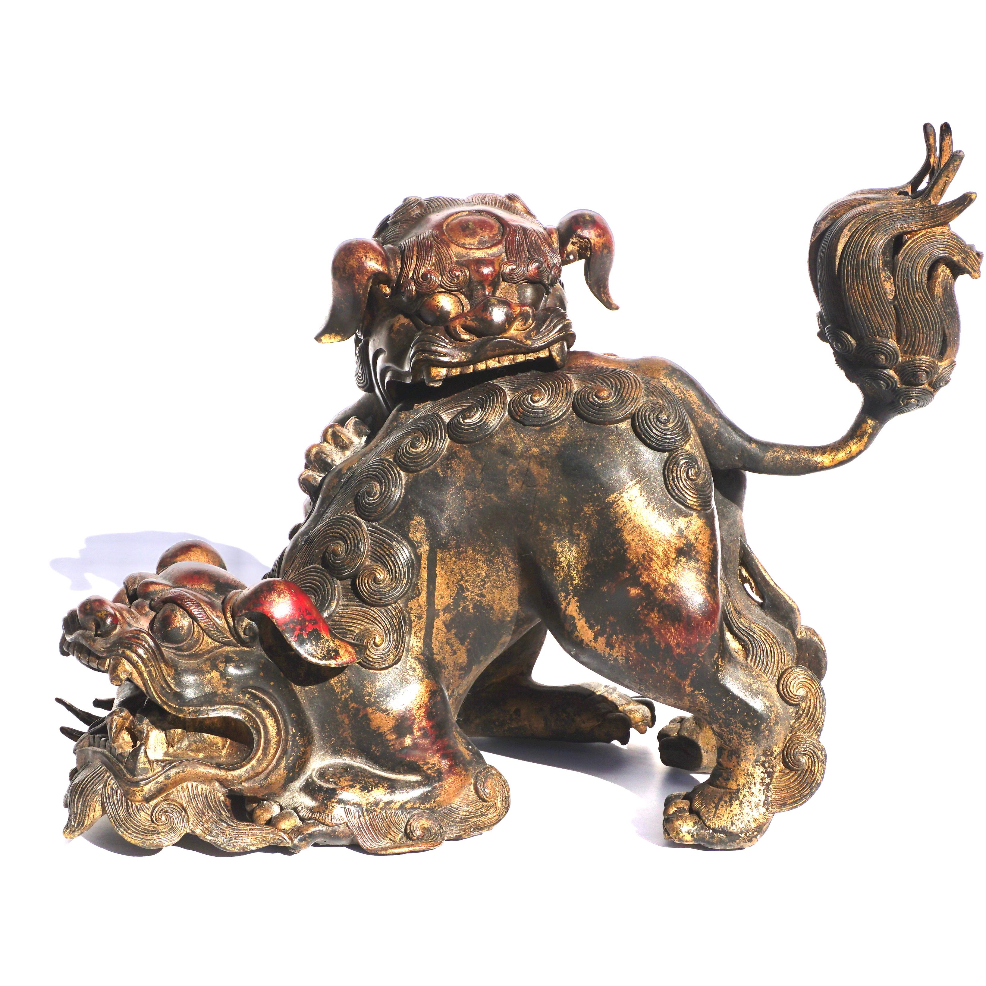 Bronze Gilt and lacquered Incense Burner
Qing Dynasty, Circa 1880
Ming Style

A whimsical and playful pair of attached foo dogs. One dog is biting the back of his partner who is chewing on his foot. The top head comes off to place incense inside