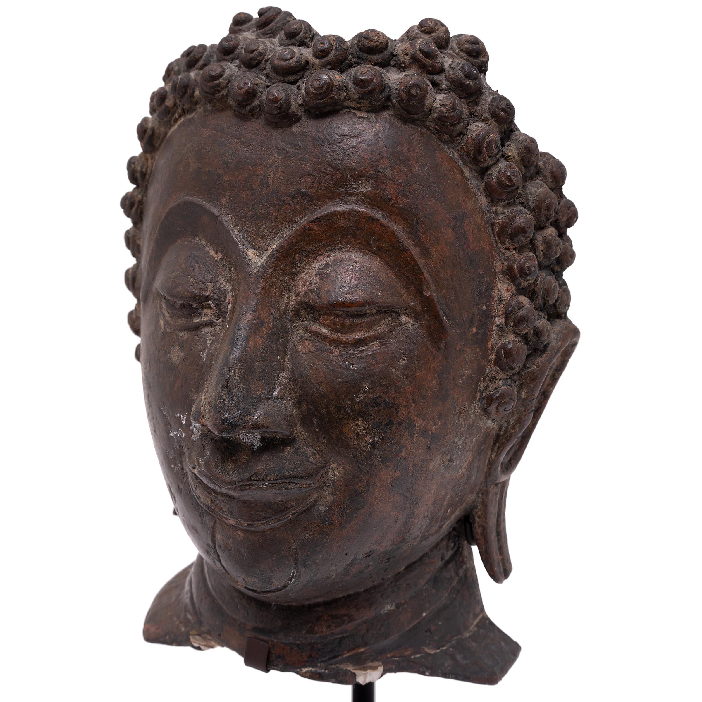 Dated to the early 19th-century, this cast bronze bust depicts the serene face of the historical Buddha, known also as Shaka, Shakyamuni, or Siddhartha Gautama. The most common subject in Buddhist iconography, the Buddha Shakyamuni is revered as a