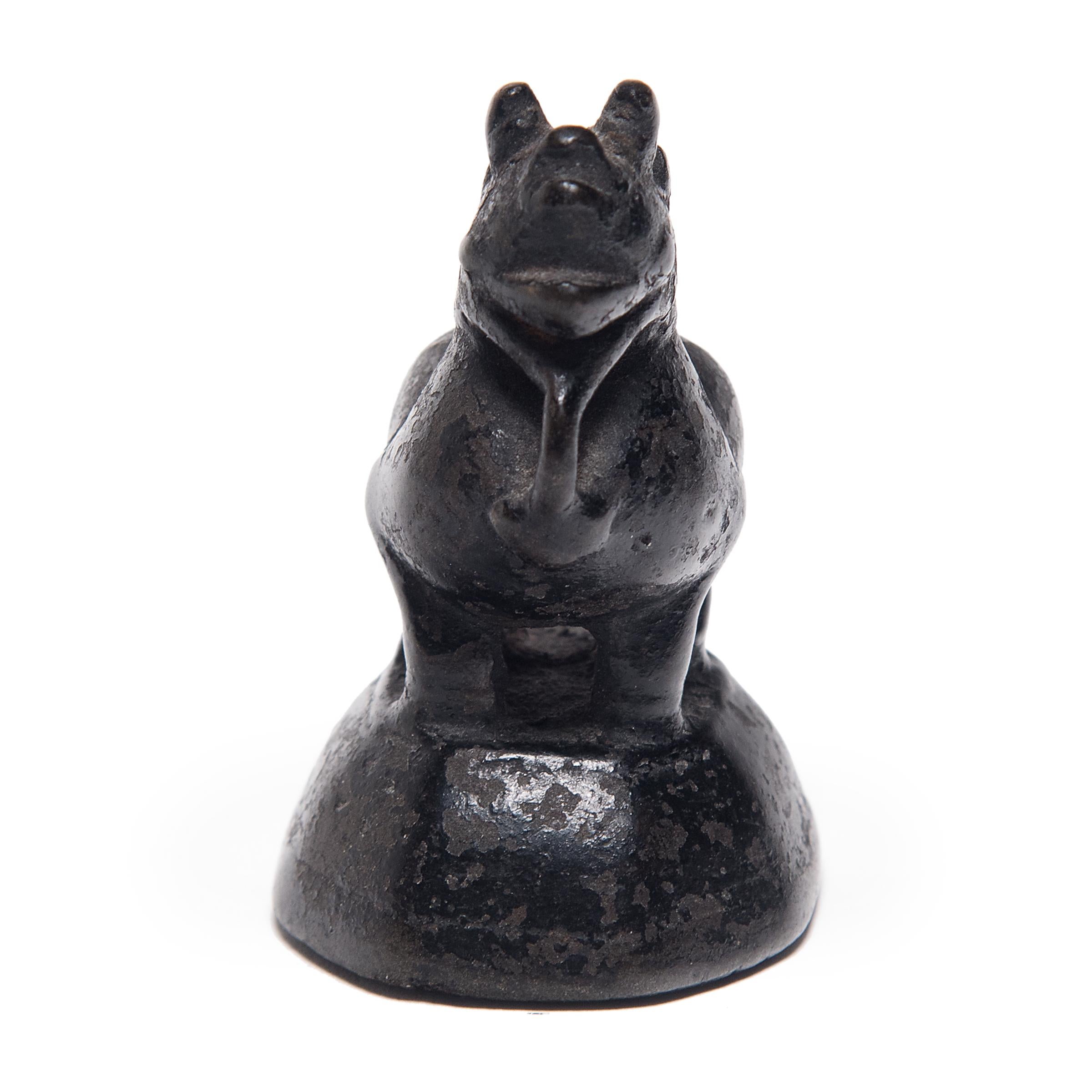 Whether used to parcel out opium, spices, or other valuable goods, this small figurine was originally used as a counterweight for a tabletop balance. Cast in bronze, the petite weight takes the form of a mythical guardian fu dog, or shizi. A symbol