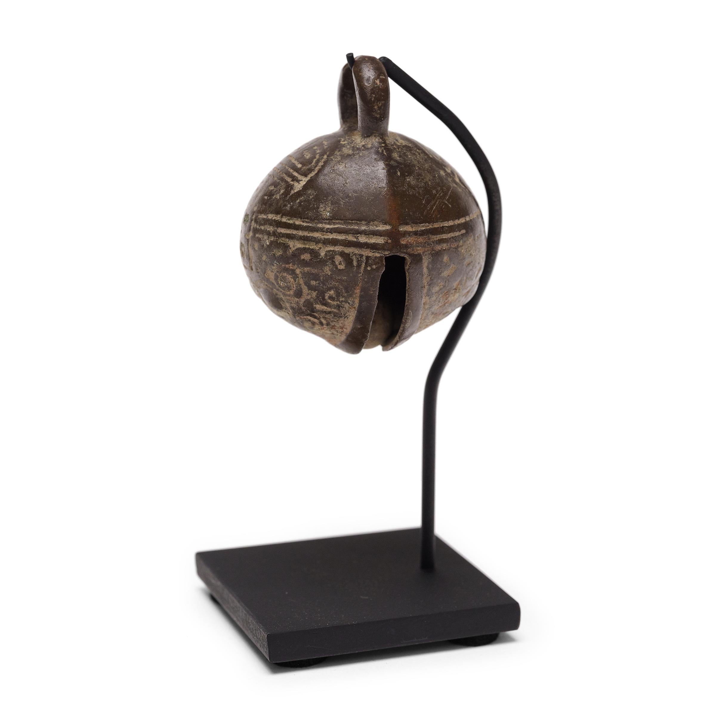 This large Sino-Tibetan bronze bell was originally used to track the movement of livestock. This distinctive spherical form was mostly worn by larger animals such as elephants, oxen and cows so that they could be located while they roamed free to