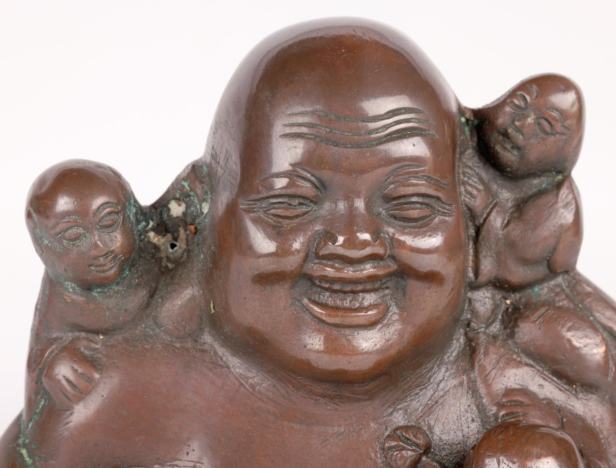 A fine Chinese bronzed copper seated Buddha with five small boys believed to date from the early 20th century. The hollow cast figure is well detailed and portrays the seated smiling Buddha with the open customary robe showing his large stomach and