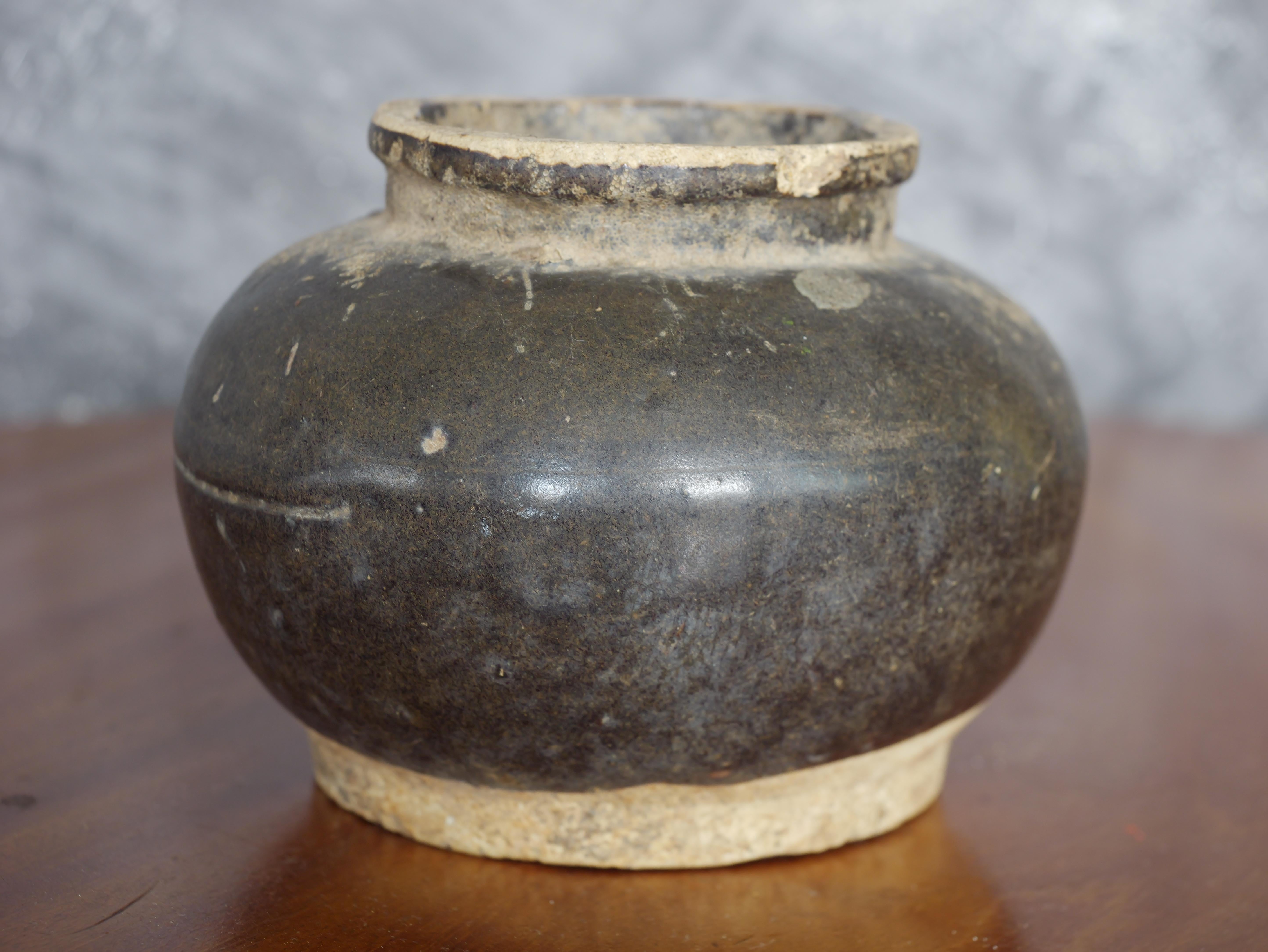 Dieser chinesische, braun glasierte Steingutkrug aus der Song-Dynastie ist trotz seines Alters und leichter Beschädigungen ein bemerkenswertes Stück. Das Gefäß weist eine reiche braune Glasur auf, die typisch für die Keramik der Song-Dynastie ist,