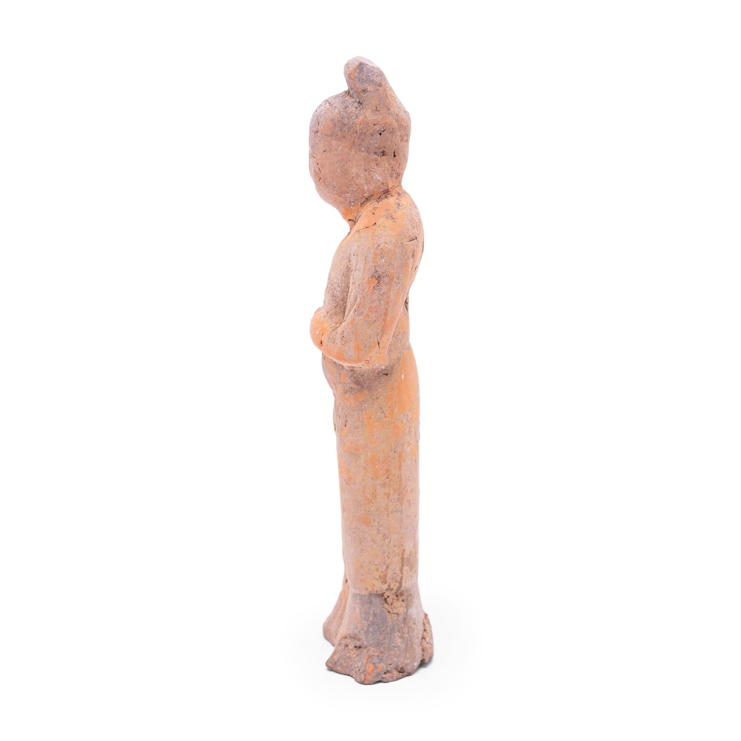 Moulée en terre cuite, cette petite sculpture est un type de figurine funéraire vieille de plusieurs siècles, connue sous le nom de míngqì. Ces figurines étaient placées dans les tombes des personnes de haut rang pour leur assurer un voyage en toute