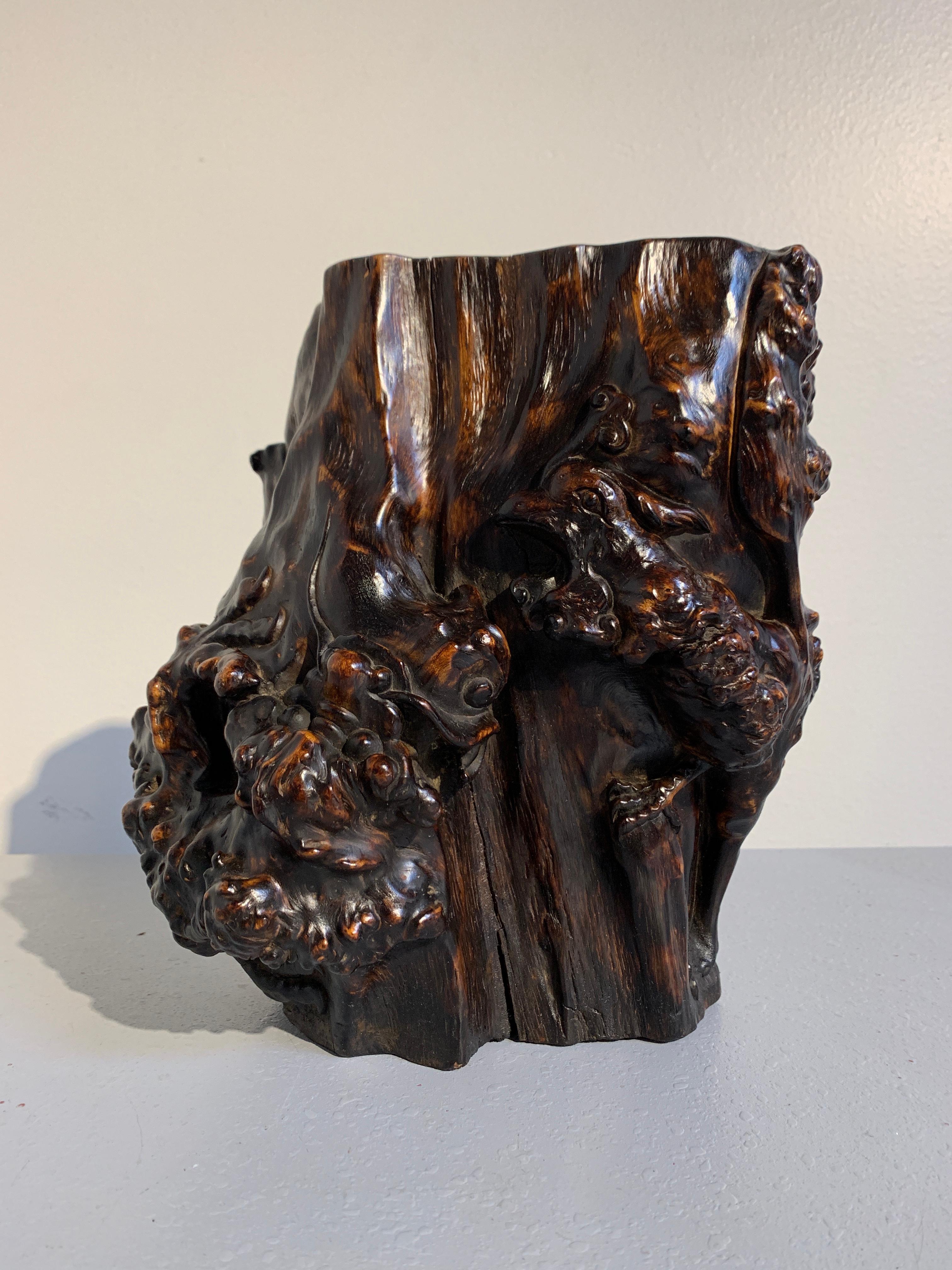 A heavy and bold Chinese hardwood burl brushpot with a craved dragon and phoenix design, late Republic Period, circa 1940. 

The brushpot of naturalistic trunk form with wonderful burl formations. Parts fo the burl carved - one side featuring the