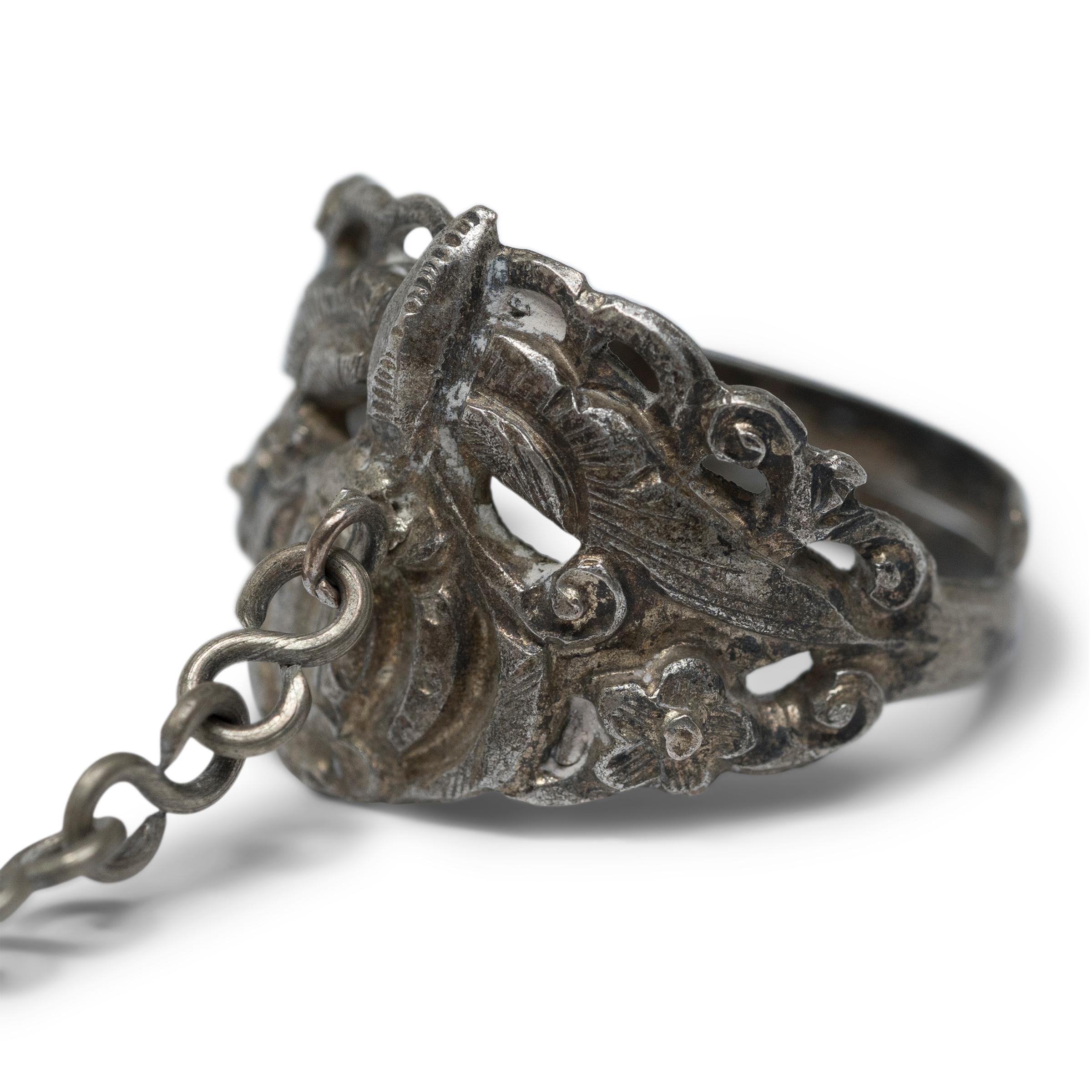 Dated to the late 19th century, this silver charm ring was believed to protect the wearer from bad luck and malevolent spirits. The ring is decorated in relief with a round gourd and a butterfly among outstretching vines. This motif of a butterfly