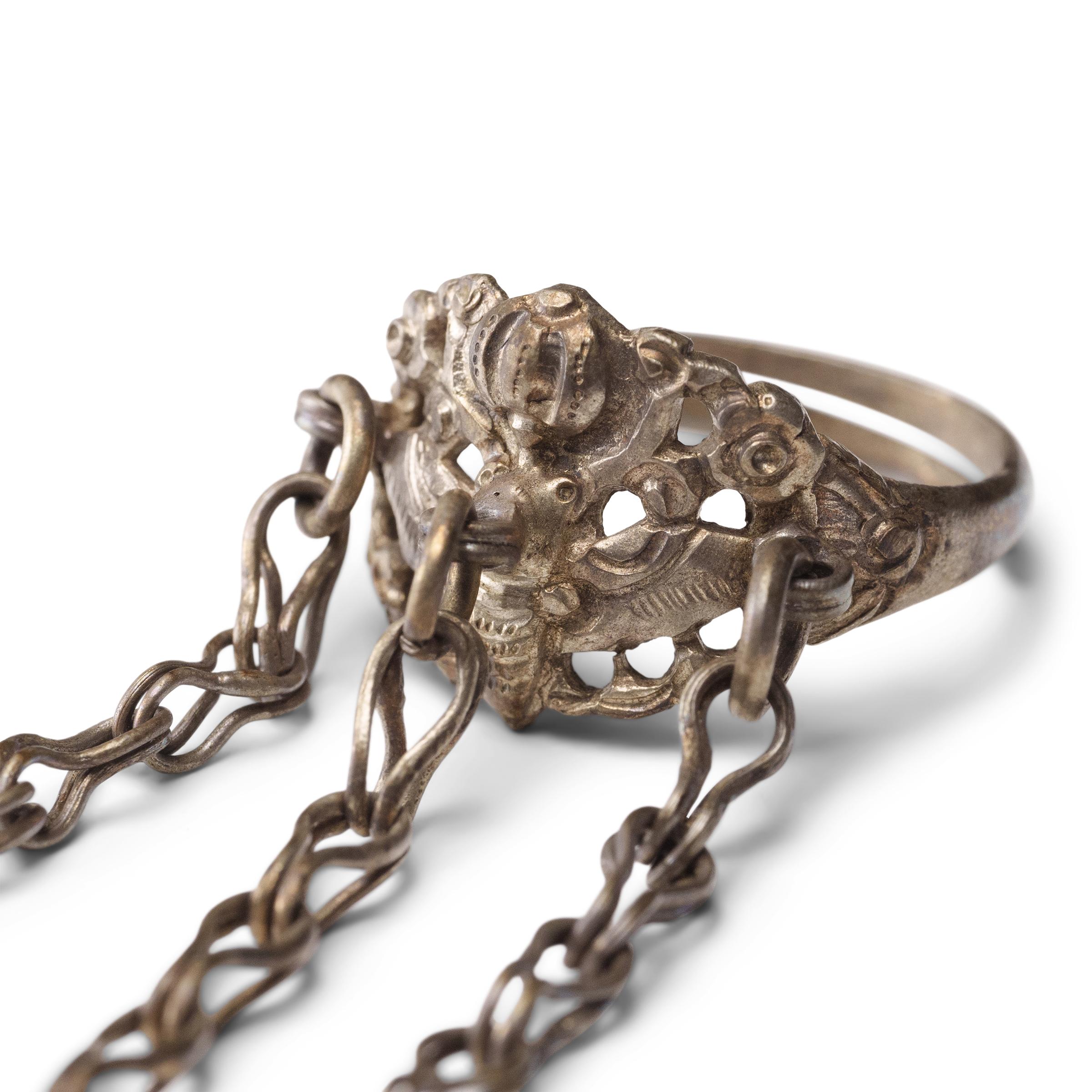 Dated to the late 19th century, this silver charm ring was crafted by the Miao peoples of Guizhou province and was believed to protect the wearer from bad luck and malevolent spirits. The ring band has a pierced, low relief design of a round gourd