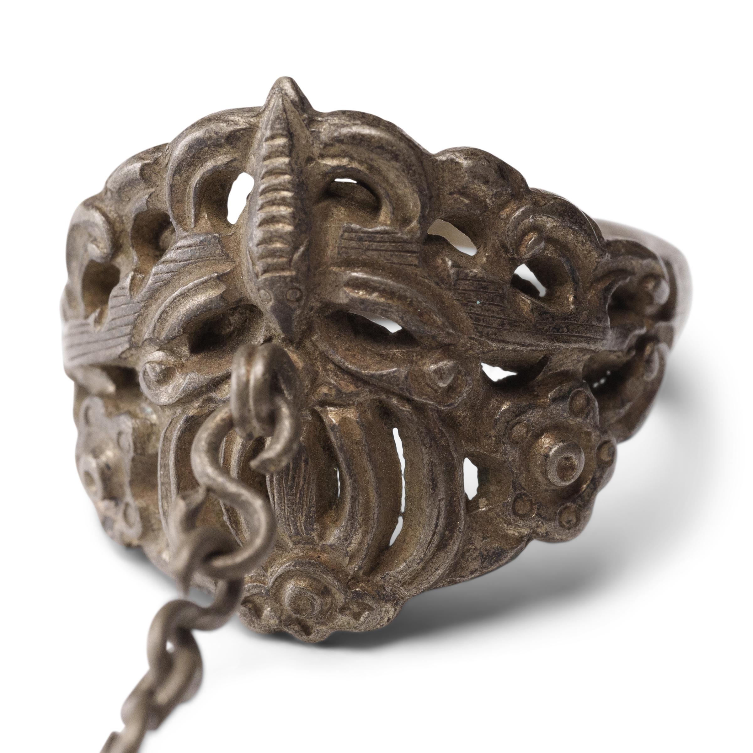 Dated to the late 19th century, this silver charm ring was crafted by the Miao peoples of the Guizhou province and was believed to protect the wearer from bad luck and malevolent spirits. The ring is decorated with a pierced, low relief design of a