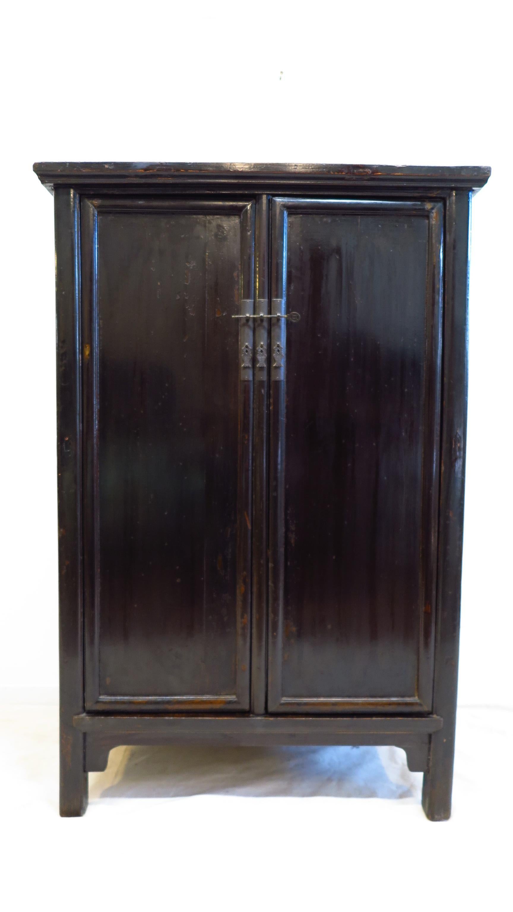 19th century black lacquer Chinese cabinet. Referred to as a Chinese round corner cabinet, also a book cabinet. Wood hinged doors with a removable center stile. Two drawers inside with shelf space of 21H top and 19H bottom. Shandong, 1830-1850.