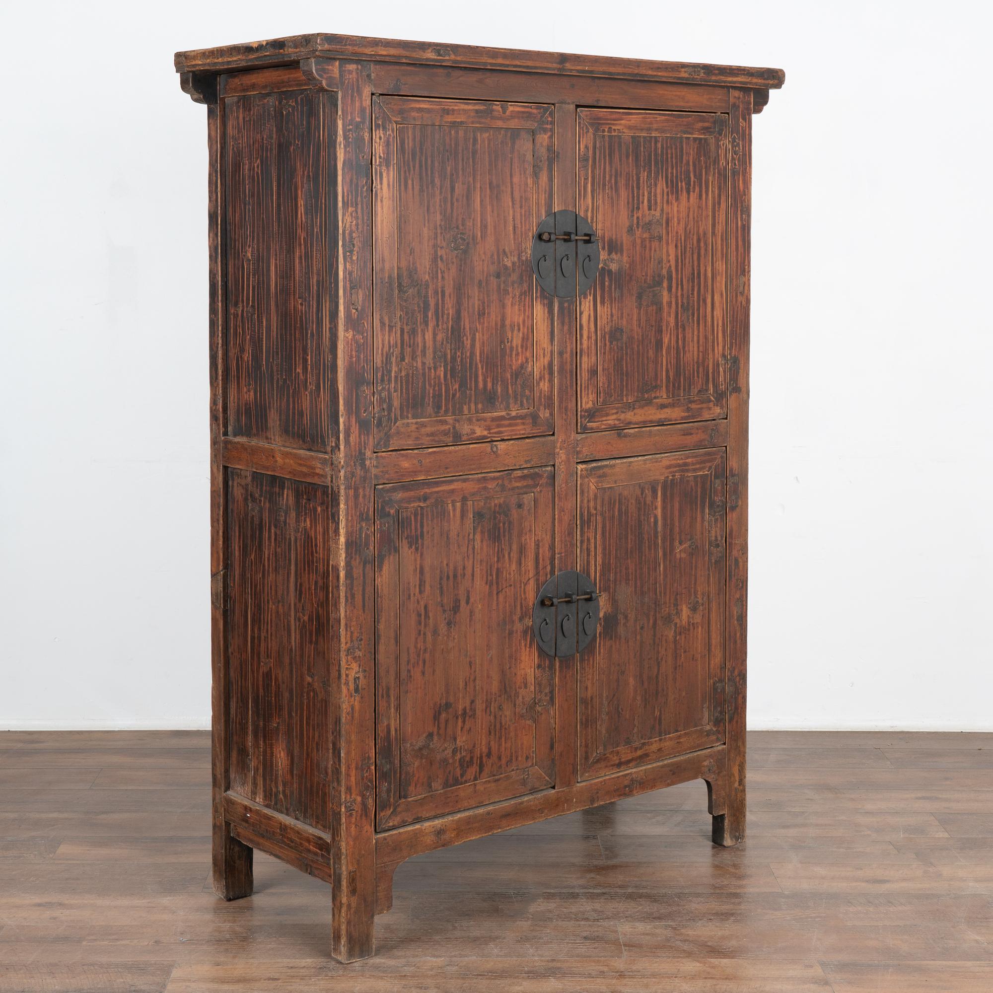 The superb quality of this Chinese cabinet is largely due to the exceptional finish. The old brown painted finish has slight red undertones and is accentuated by a hand buffed finish, leaving a warm organic feel to this armoire.
Restored (new