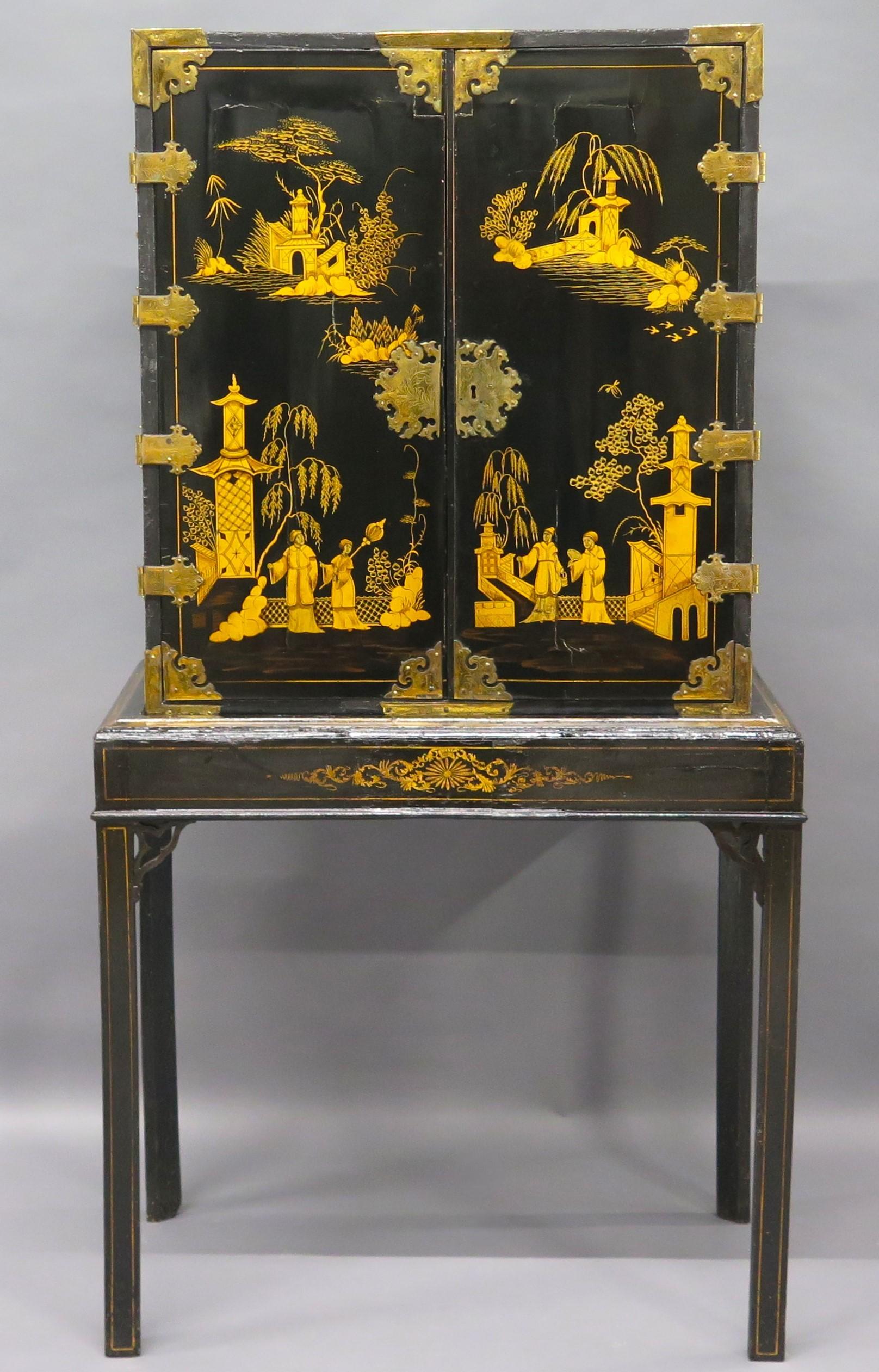 an opulent black lacquer Chinese Export Collector's Cabinet on Stand with detailed gilt landscape and figural decoration, the shaped hinges and corners all appear to be gilt on brass, the original side lift handles are of the Chippendale style, the