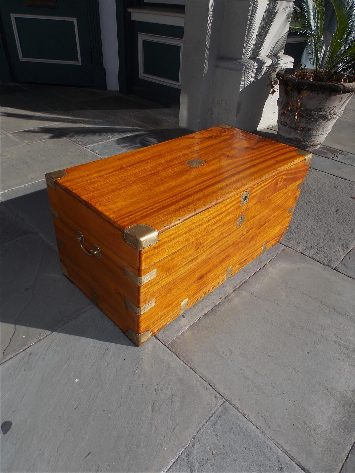 Chinese camphor wood hinged traveling trunk with brass exterior mounts, original brass carrying side handles, centered ring pull, and retains the original interior locking mechanism, Early 19th century. Great use for coffee table or linen storage.