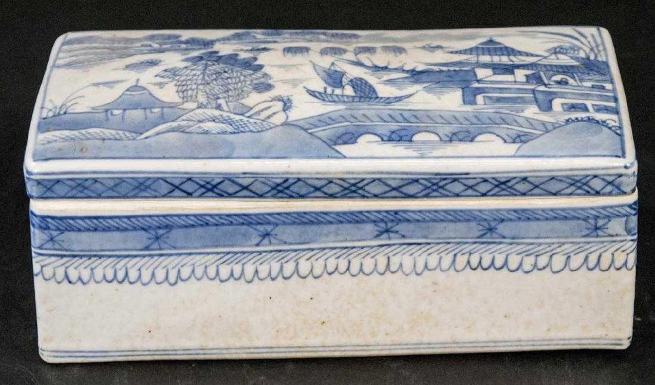 The vintage Chinese canton blue and white export porcelain box has a fitted lid and features a hand painted riverside village scene on top.