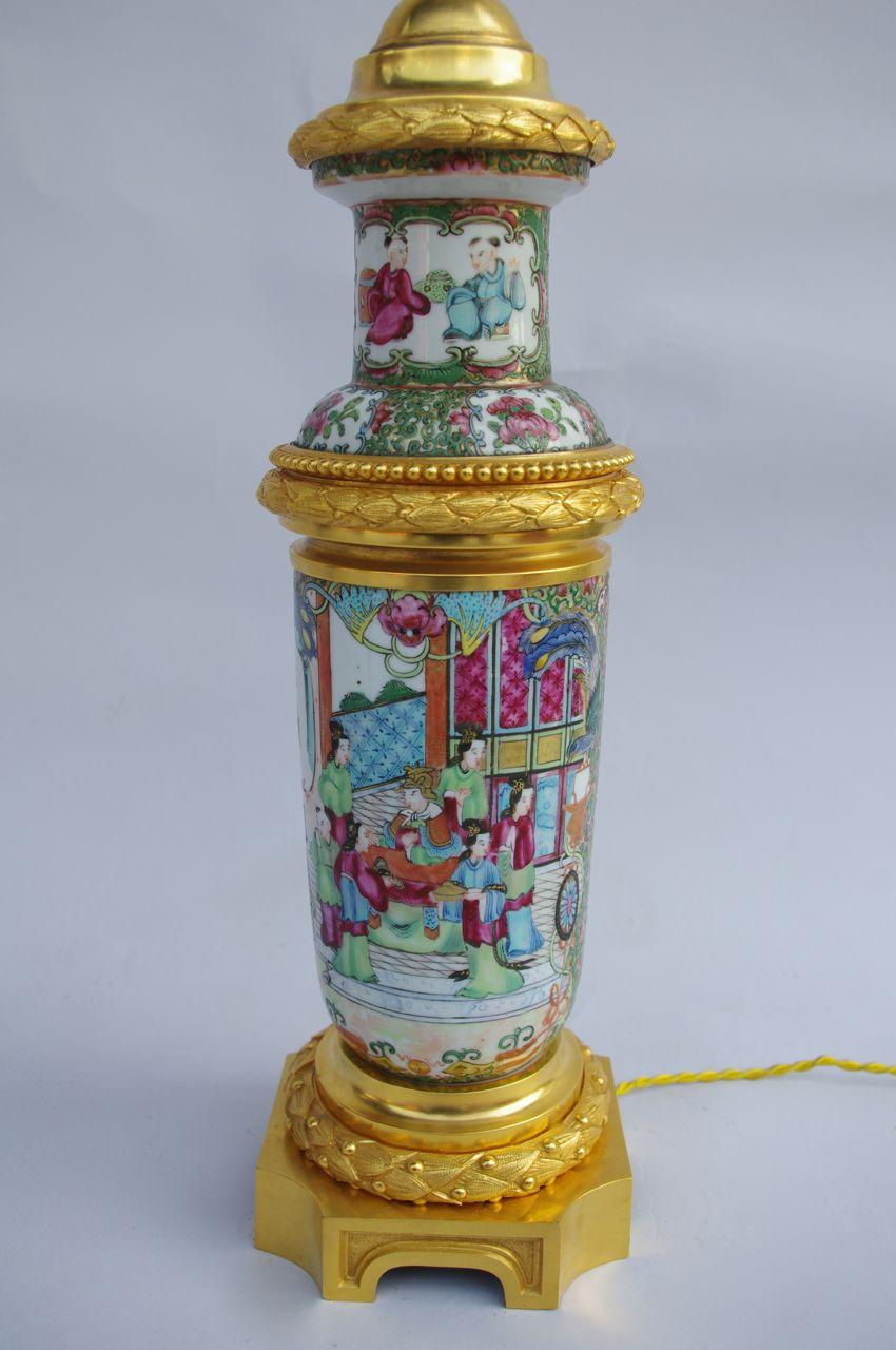 Cylindrical Canton porcelain on a white background with polychromatic ornamentation. Adorned with vivid colors representing Chinese characters in their palace, but also plants, animals such as peacock, roosters or butterflies.
Chiselled and gilt