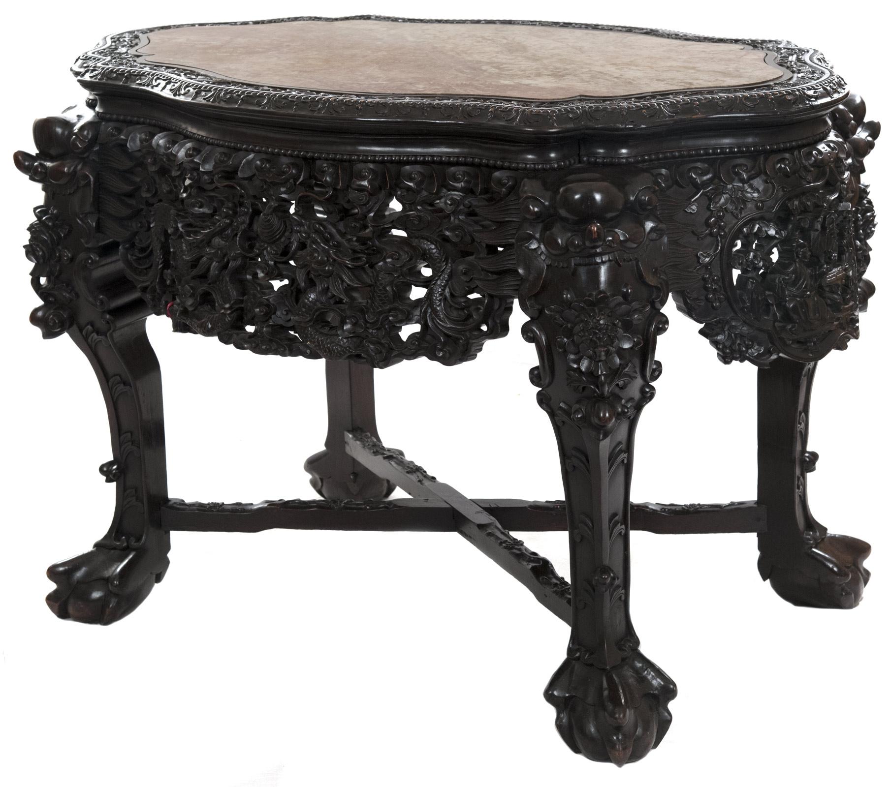 A 19th century Chinese captured-top table inset with a cartouche-shaped rouge marble top bordered by a carved and stepped edge above an elaborately carved and pierced apron with ornate dragon, floral, cloud and vine motifs. The richly carved legs,