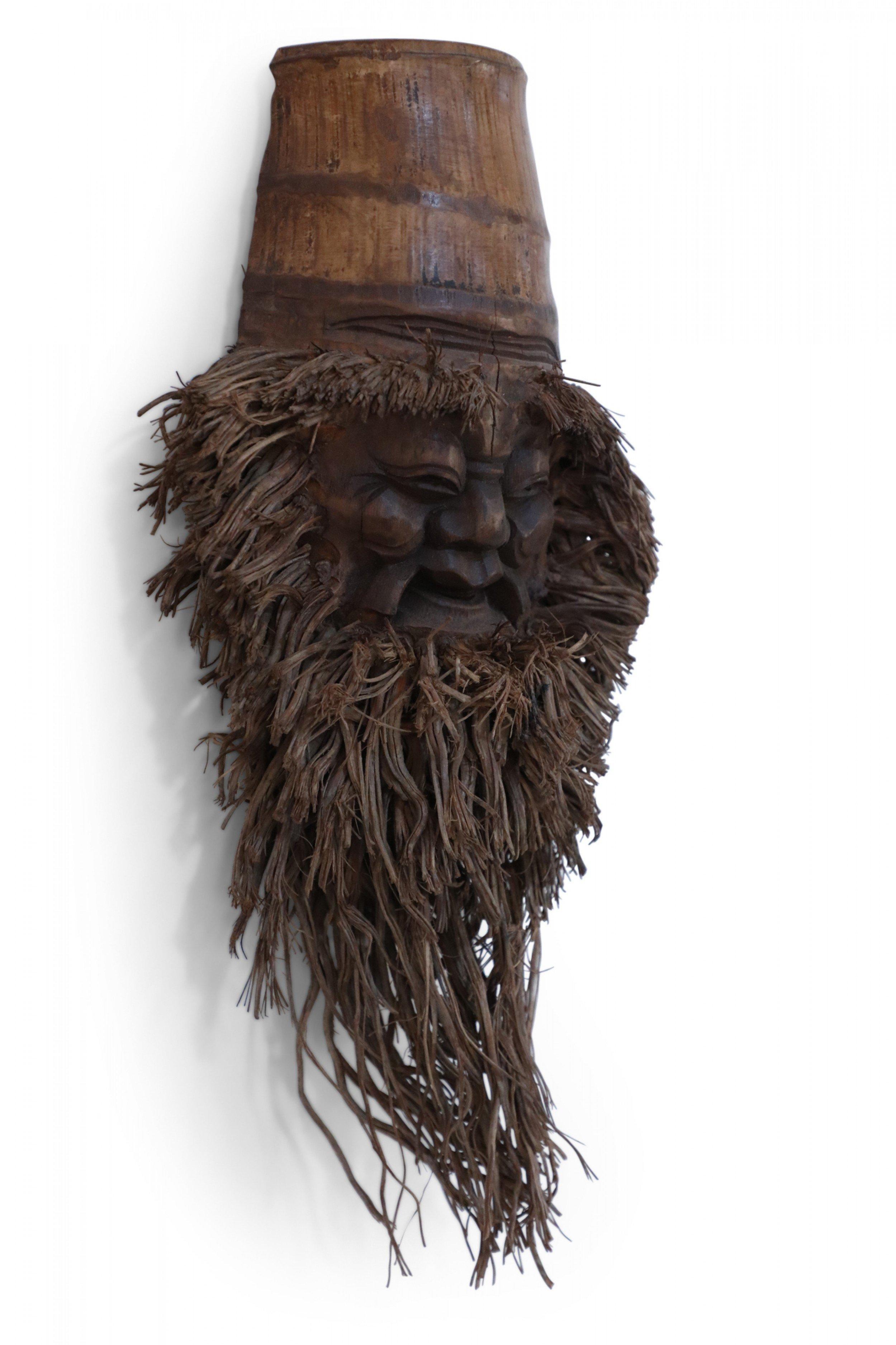 Chinese wall plaque made from a bamboo root carved in the shape of a smiling face with a bamboo root fiber beard. (Companion pieces: NWL2543A-G).
  