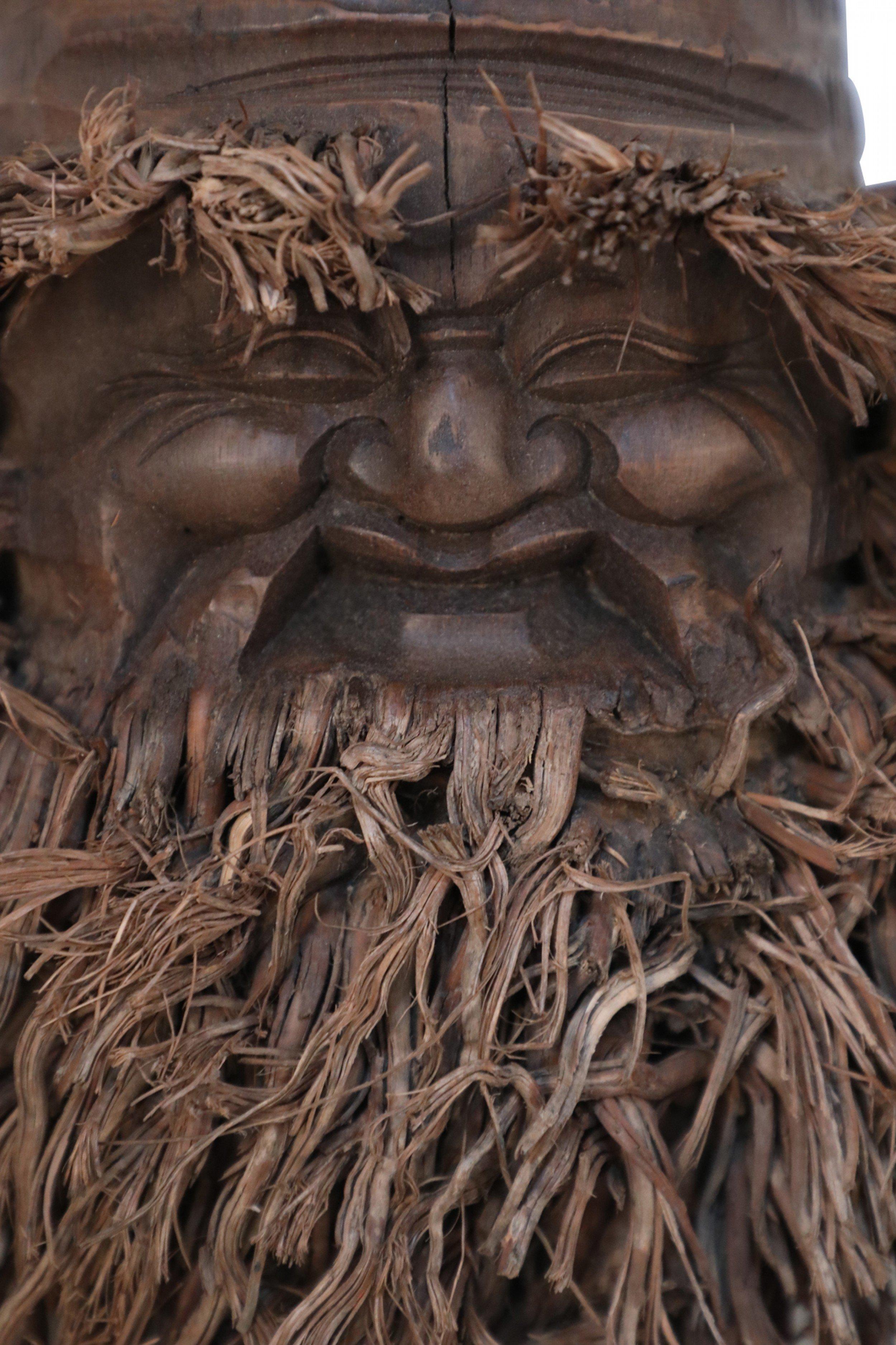 Chinese wall plaque made from a bamboo root carved in the shape of a smiling face with a bamboo root fiber beard.
     