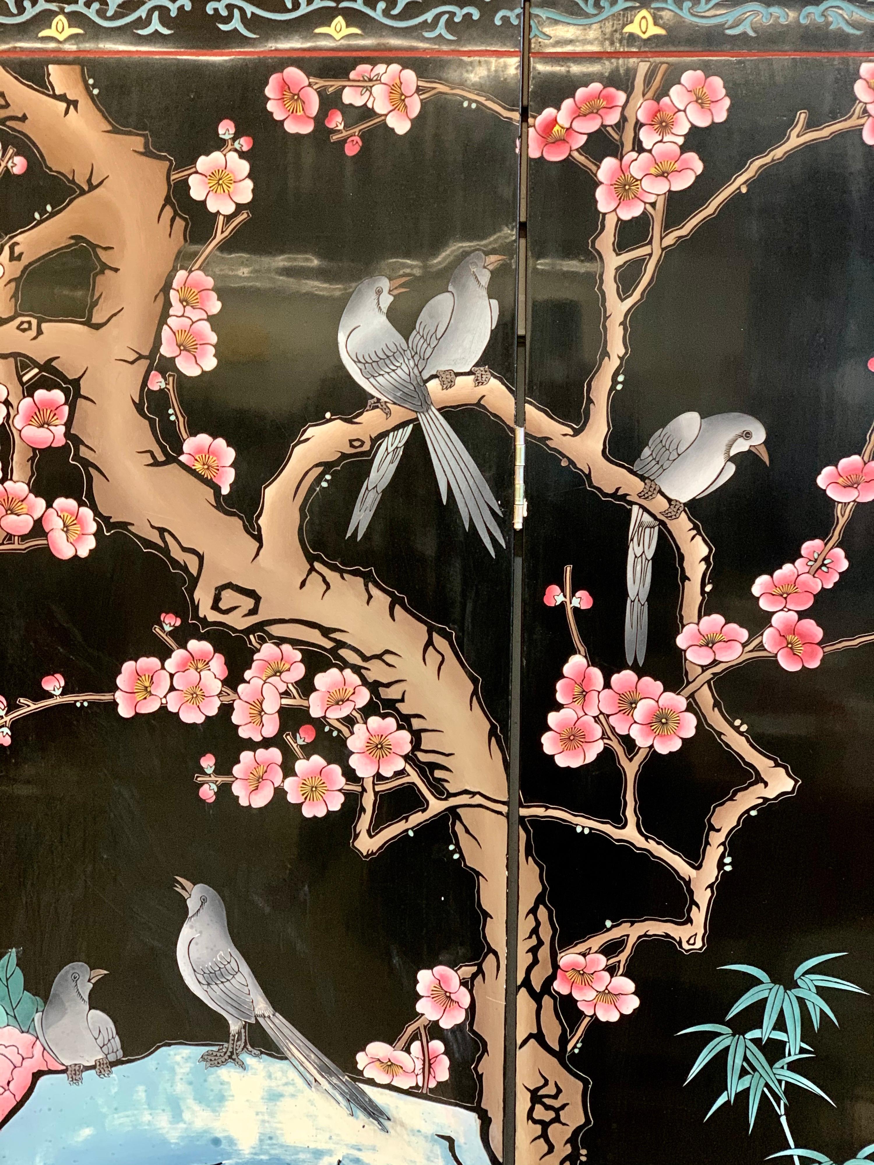 Stunning Chinese export style black lacquer four-panel screen or room divider. What sets this screen apart from the rest is the vivid colors, including pink and blue, that adorn this piece. The screen expands to a max width of 64