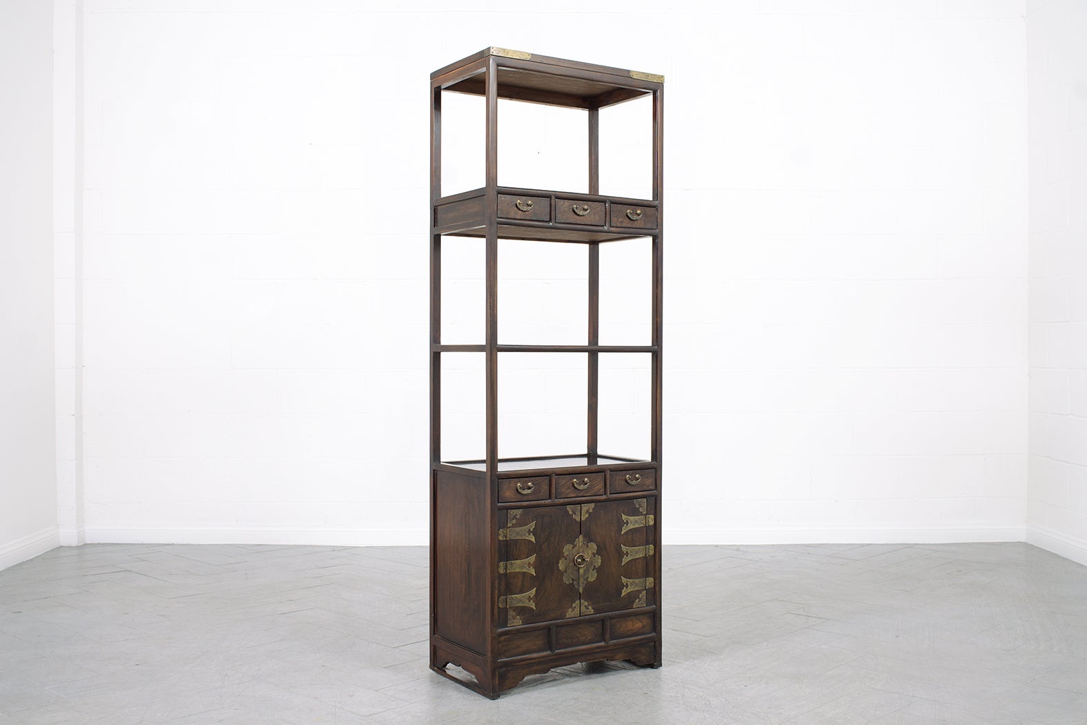 Revel in the timeless beauty of our vintage Chinese bookcase, a testament to enduring artistry from days past. Every inch of this piece, meticulously crafted from sturdy elm wood, exudes charm and sophistication. The rich walnut color, painstakingly
