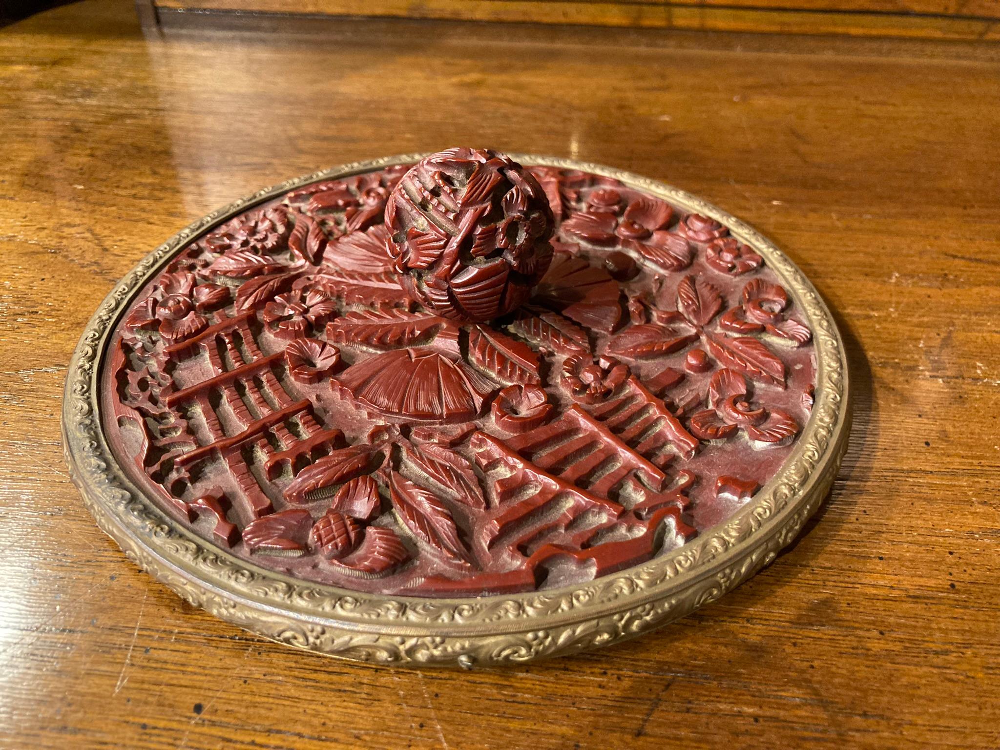 Chinesischer Zinnober-Lack-Handspiegel, mit floralen und rustikalen Gartenzäunen als Dekoration, alles in tiefem Relief geschnitzt. Gekrönt von einem runden Knopf, ebenfalls mit Blumenmuster. Eingefasst in einen Messingrahmen mit dem originalen