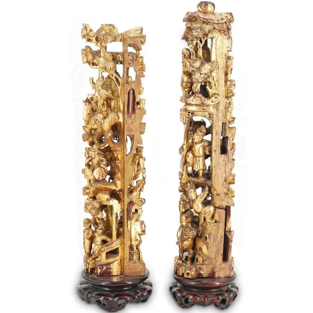 Our Chinese table ornaments from the early 20th century are finely sculpted and gilded and rest upon carved rosewood pedestals. They depict dozens of individuals engaged in various activities in the form of a tower. The tallest 18 1/2 inches.