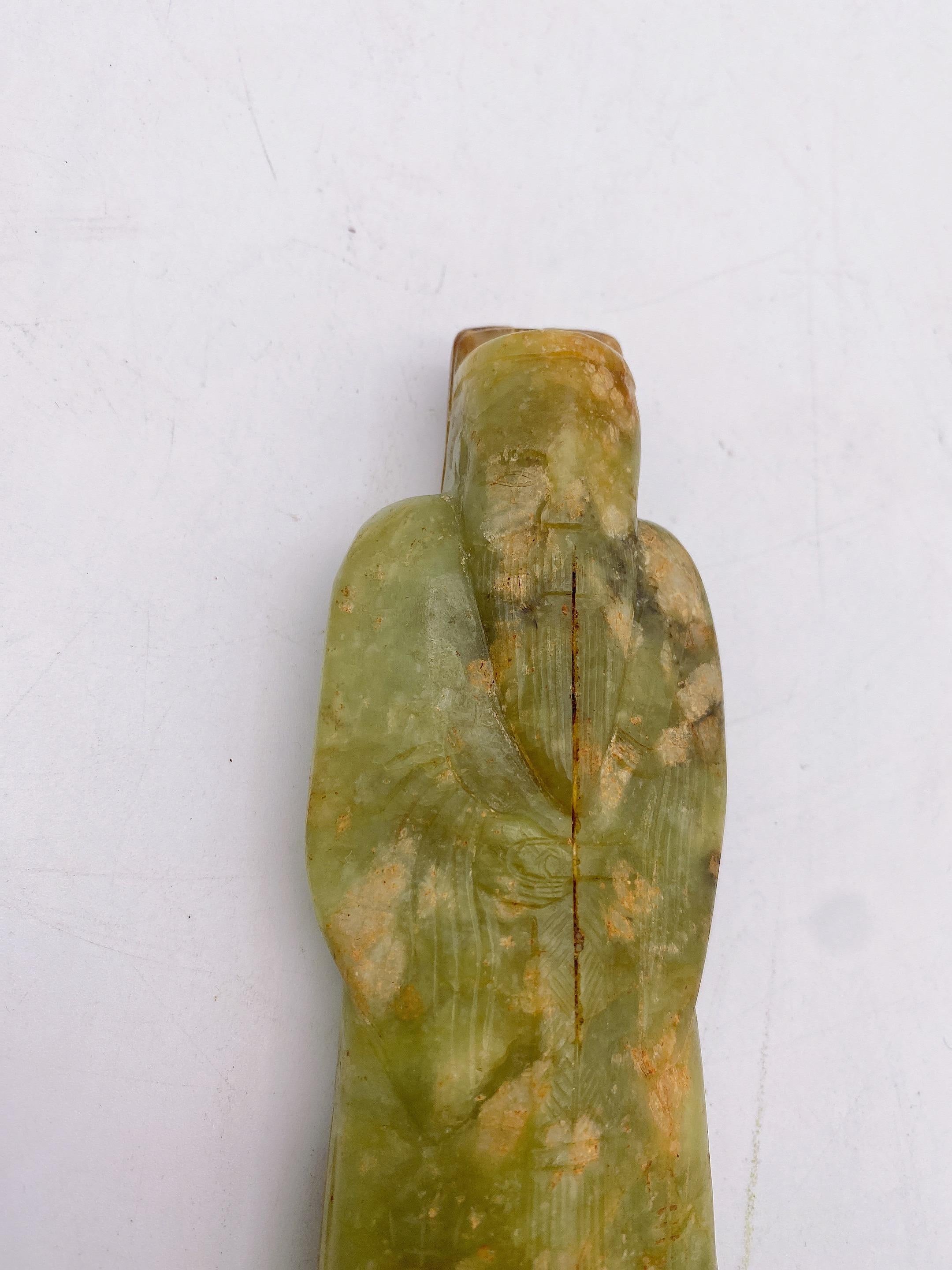 Antique an Chinese carved green river jade figure of an immortal ming/qing modelled wearing robes,
Size: 14cm x 5.5cmx 3cm. Weight 382g.