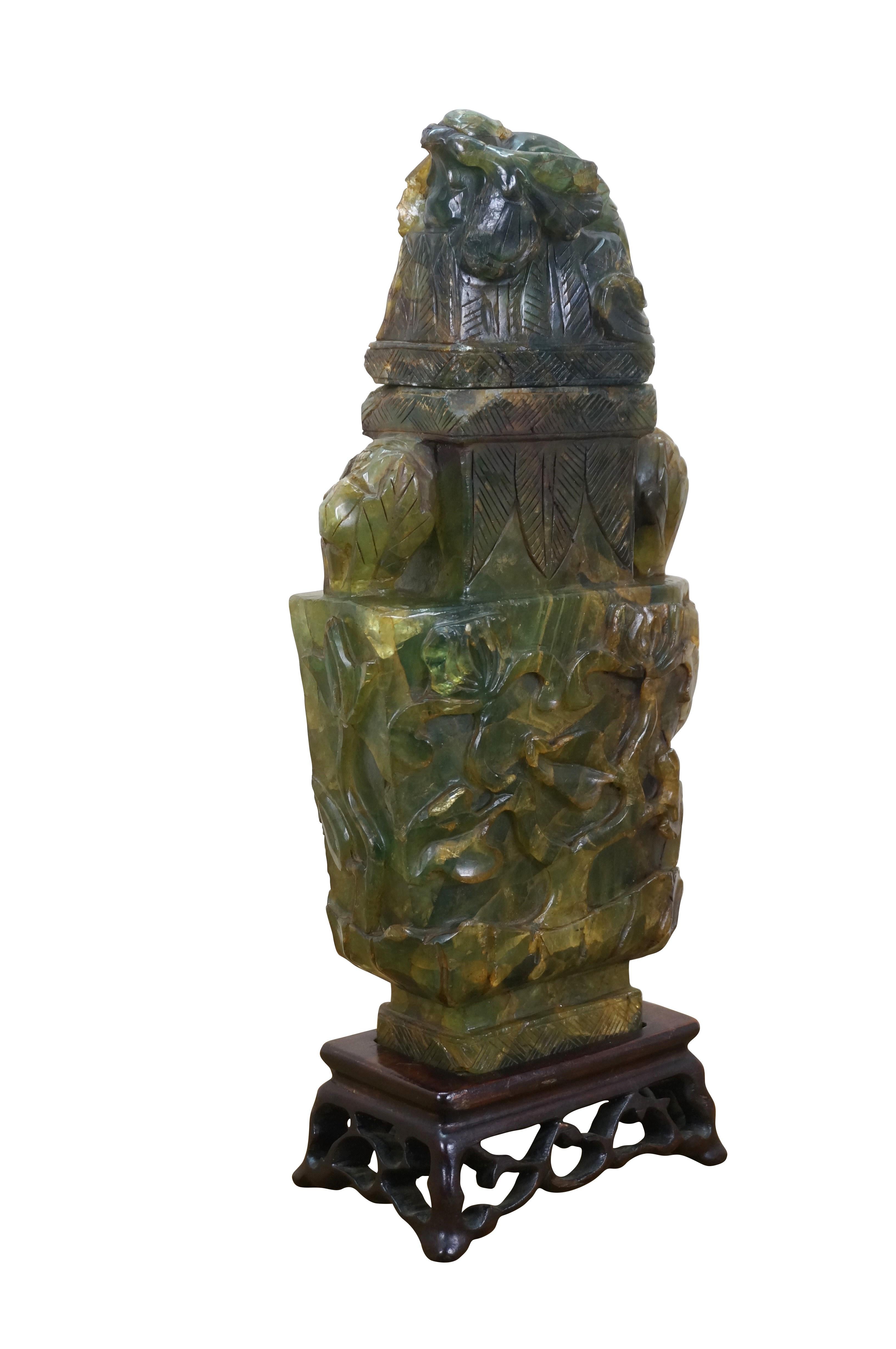 Chinese rectangular lidded mantel vase / urn / sculpture, hand carved of heavy chunks of green / yellow jade with branching flowers, large leaves and a huddled pheasant with curled tail. Set on a carved wood base.  In Chinese culture, the pheasant