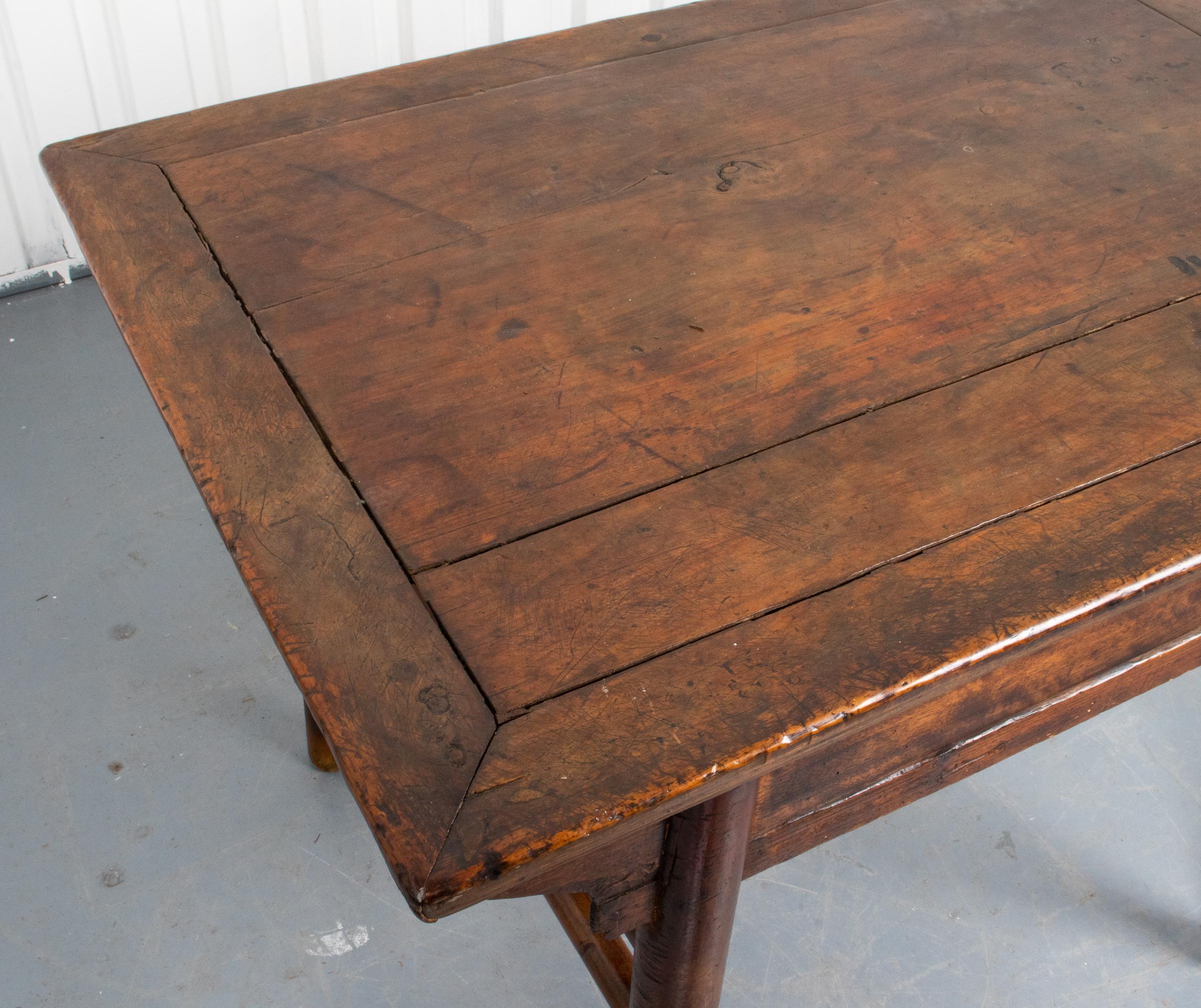 Chinese carved hardwood altar table or desk, the top and apron with inset panels, curved spandrels, and double column stretchers about the cylindrical legs. Measures: 32” H x 40.5” W x 29” D.