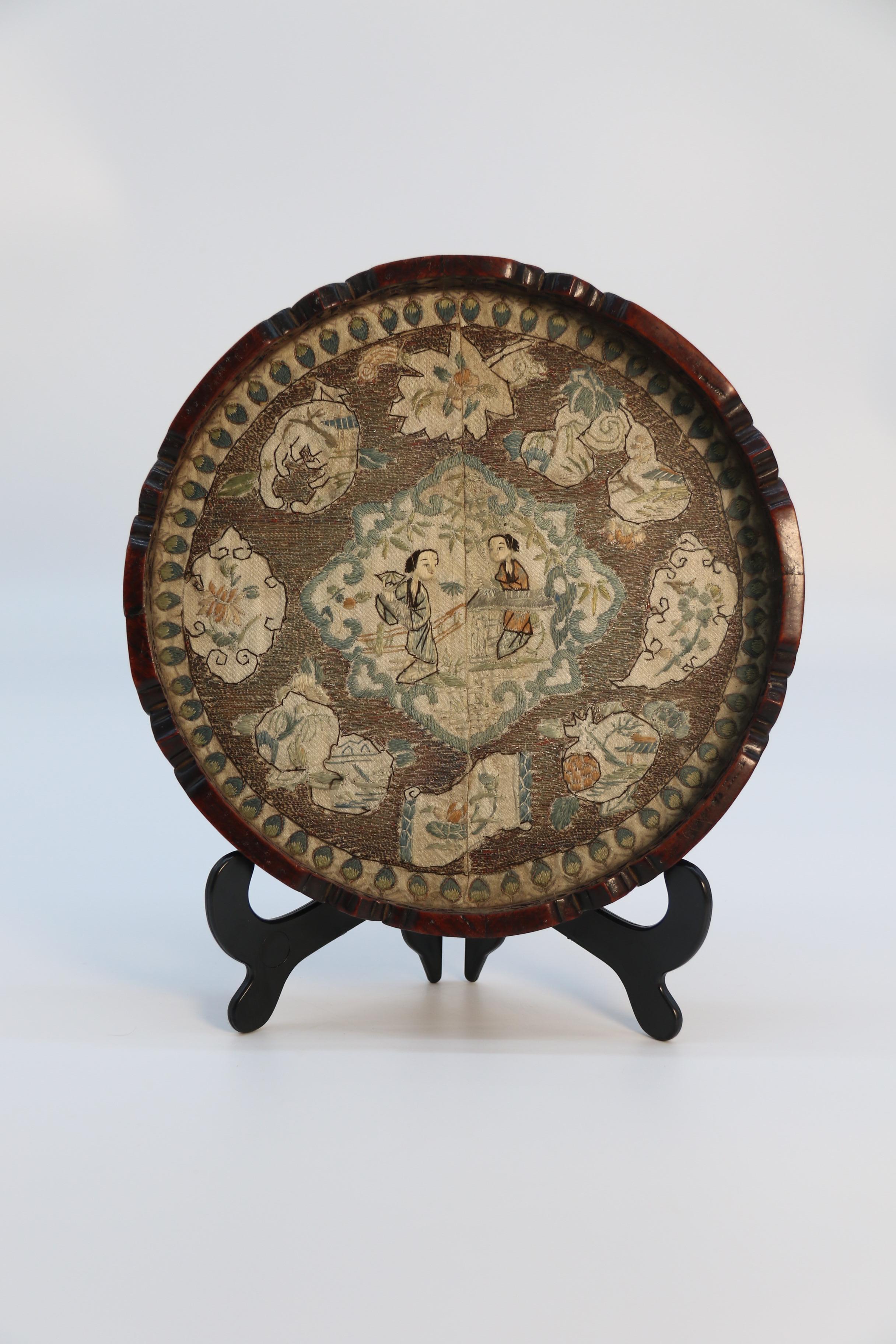Chinese Carved Hardwood and Silk Embroidered Tray, Circa 1860

This beautiful and decorative piece dates to the mid-19th century. It is a Chinese export item made for the European market. It is of circular form and has an intricately carved
