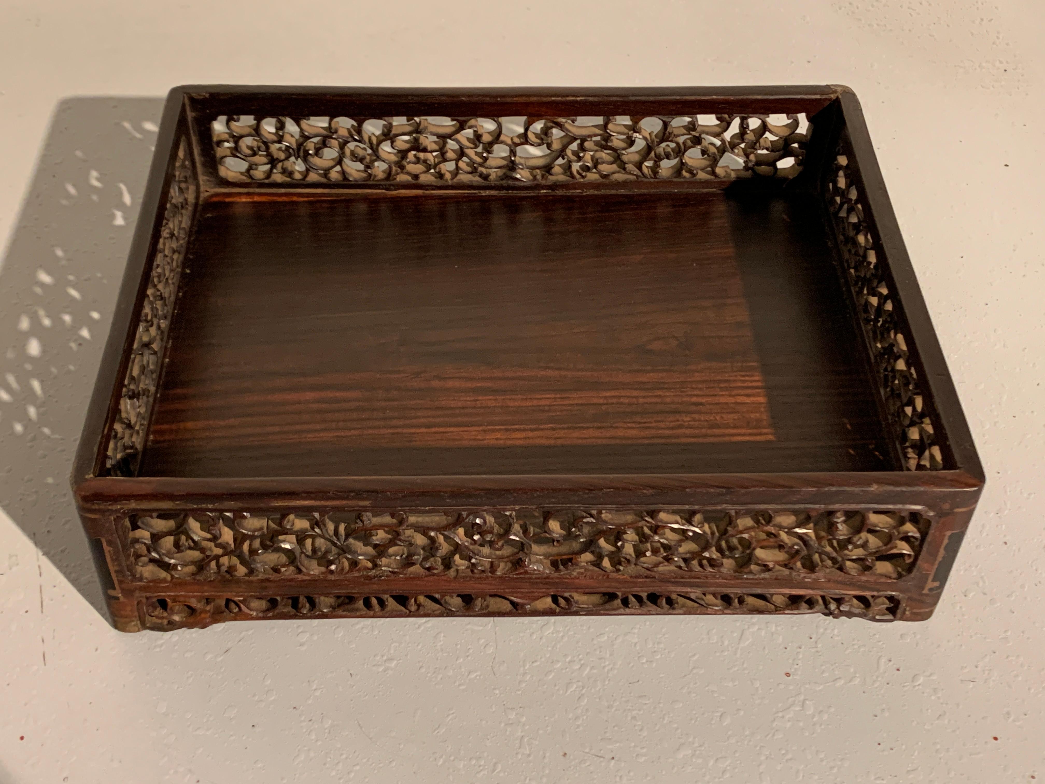 A sophisticated Chinese carved and pierced hardwood scholar's tray, Qing Dynasty, 19th century, China. 

The tray of rectangular form with high sides and rounded corners. The sides of framed floating panels delicately carved and pierced with an