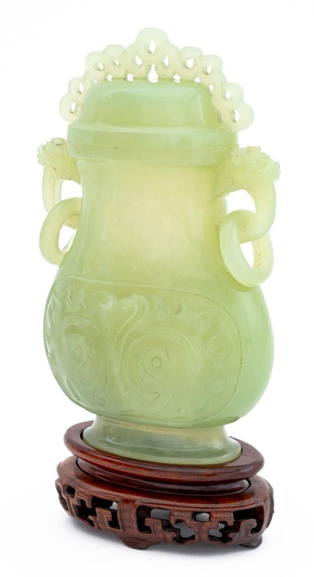 Chinesisch geschnitzte Jade bedeckt Hu Vase, mit zwei Maske Kopf mit Ringen Griffe, eingeschnitten Taotie Design auf jeder Seite, und auf einem passenden geschnitzten Holzständer. Insgesamt: 7,5