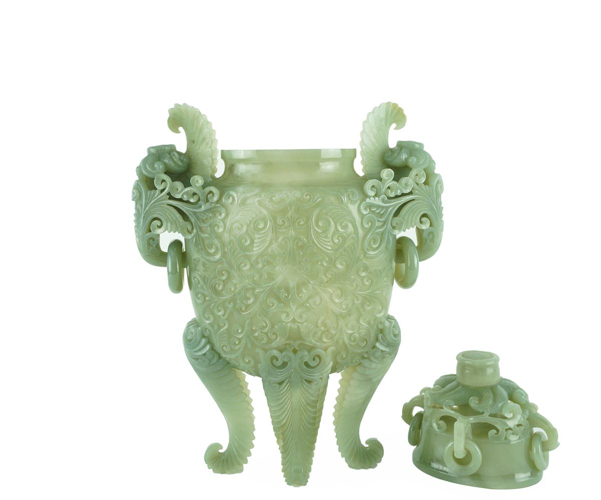 Chinese jade urn, with a floral finial and handles suspending loose rings, the flattened body carved with stylized lotus scrolls relief raised on four leafy supports. This is a stunning, well carved, very thin jade that light travels through