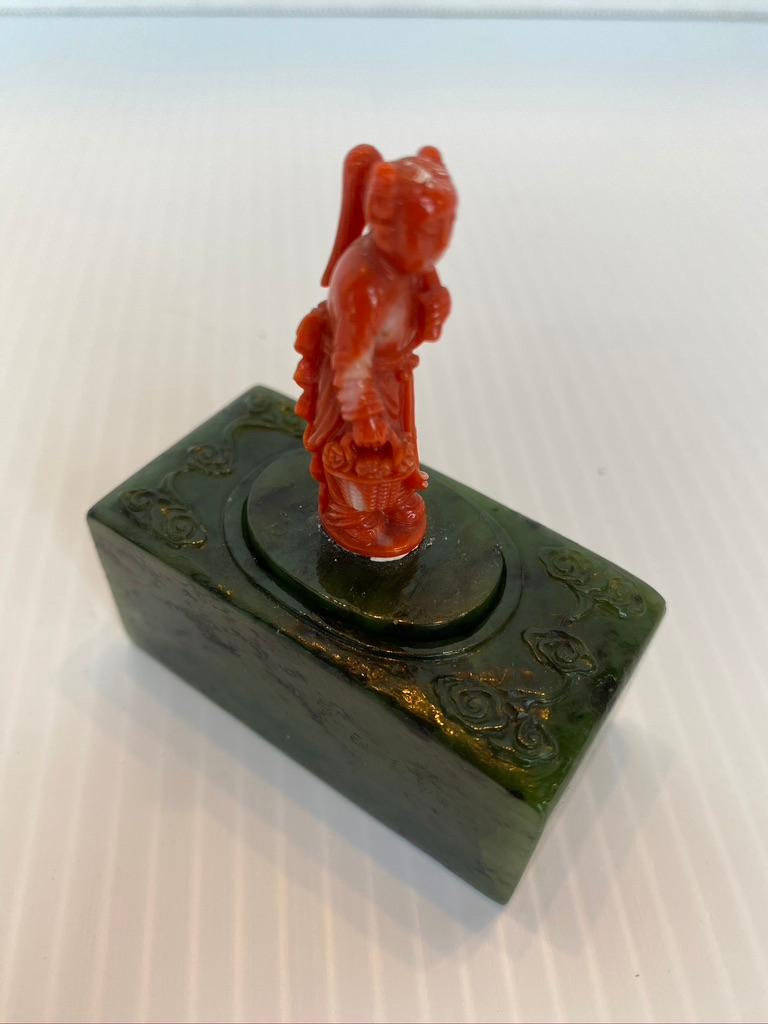Chinese carved rectangular Jadeite box with coral finial.
Hand carved from a single piece of Spinach Jade with stylized cloud design to the top and oval opening with conforming cover mounted with delicately carved figural coral finial,
circa