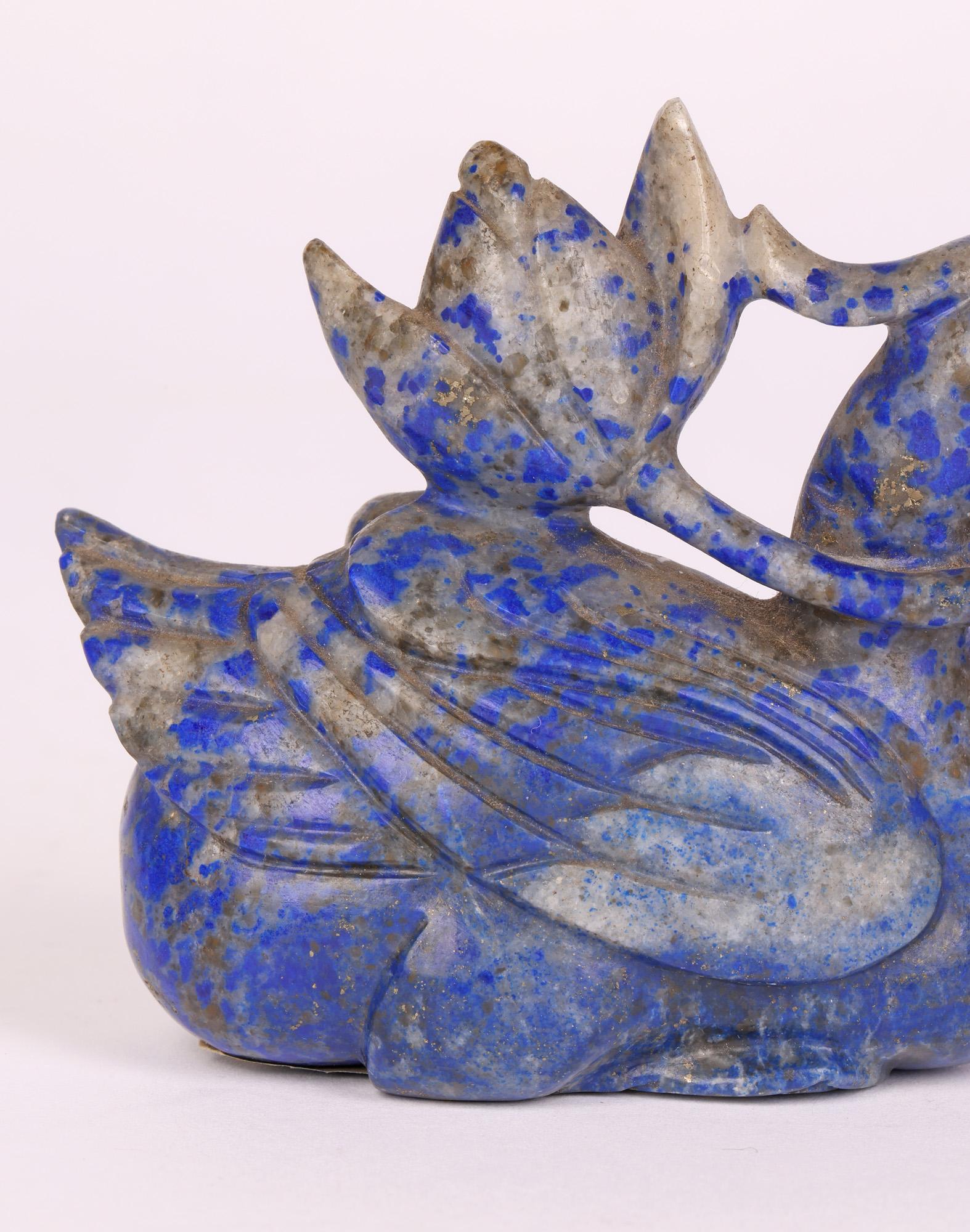 A well carved Chinese Lapis Lazuli figure of a duck with a Lotus flower probably dating from the latter 19th or early 20th century. The figure is hand carved and well detailed with the duck in a crouched (possibly swimming) position and holding a