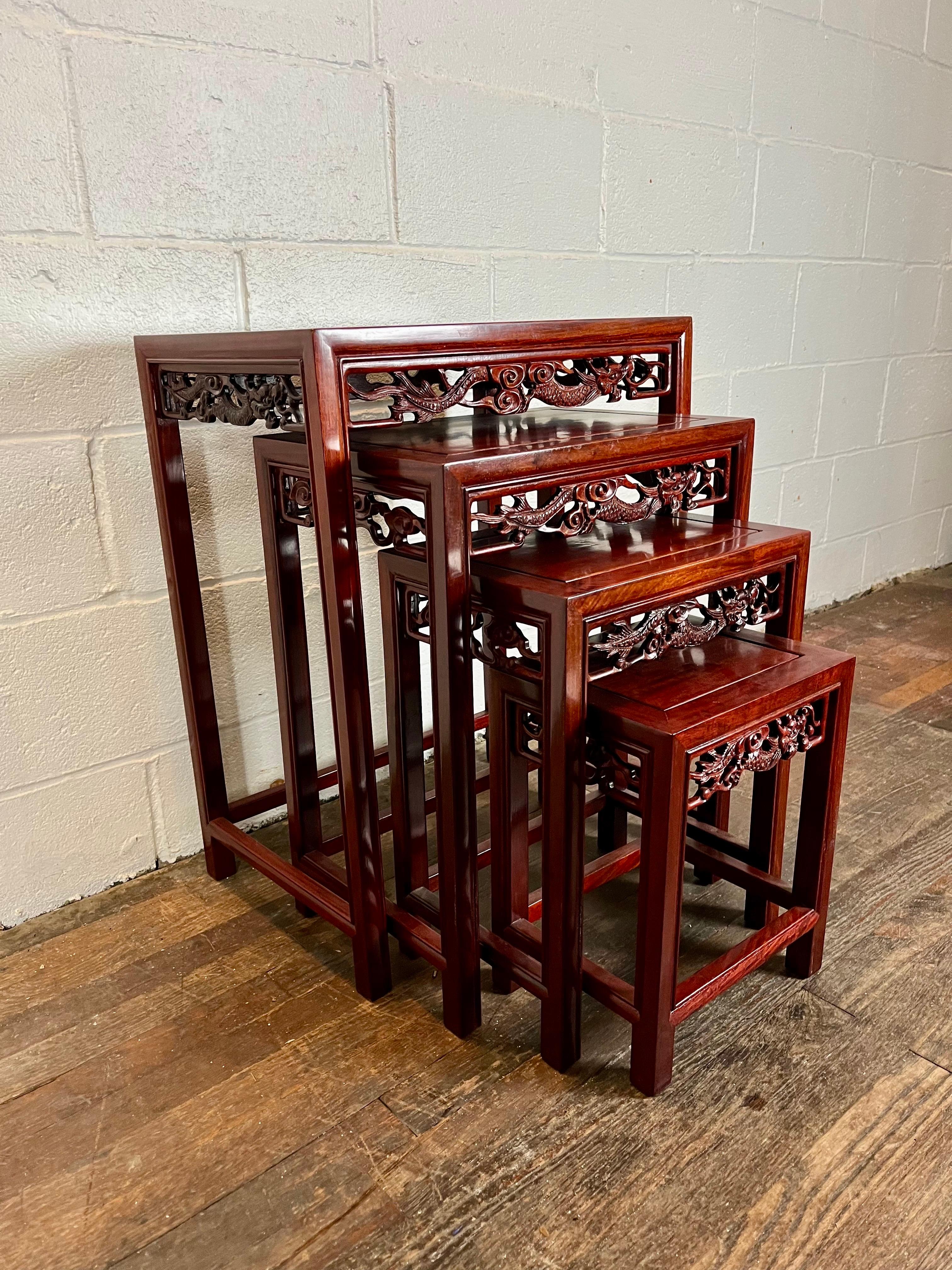 Straordinario set di quattro tavolini da salotto in ottime condizioni. Bellissimo legno massiccio di alta qualità. Rotoli intagliati con motivi di draghi. Il legno pregiato non ha bisogno di ulteriori decorazioni. Il set di 4 tavoli può essere