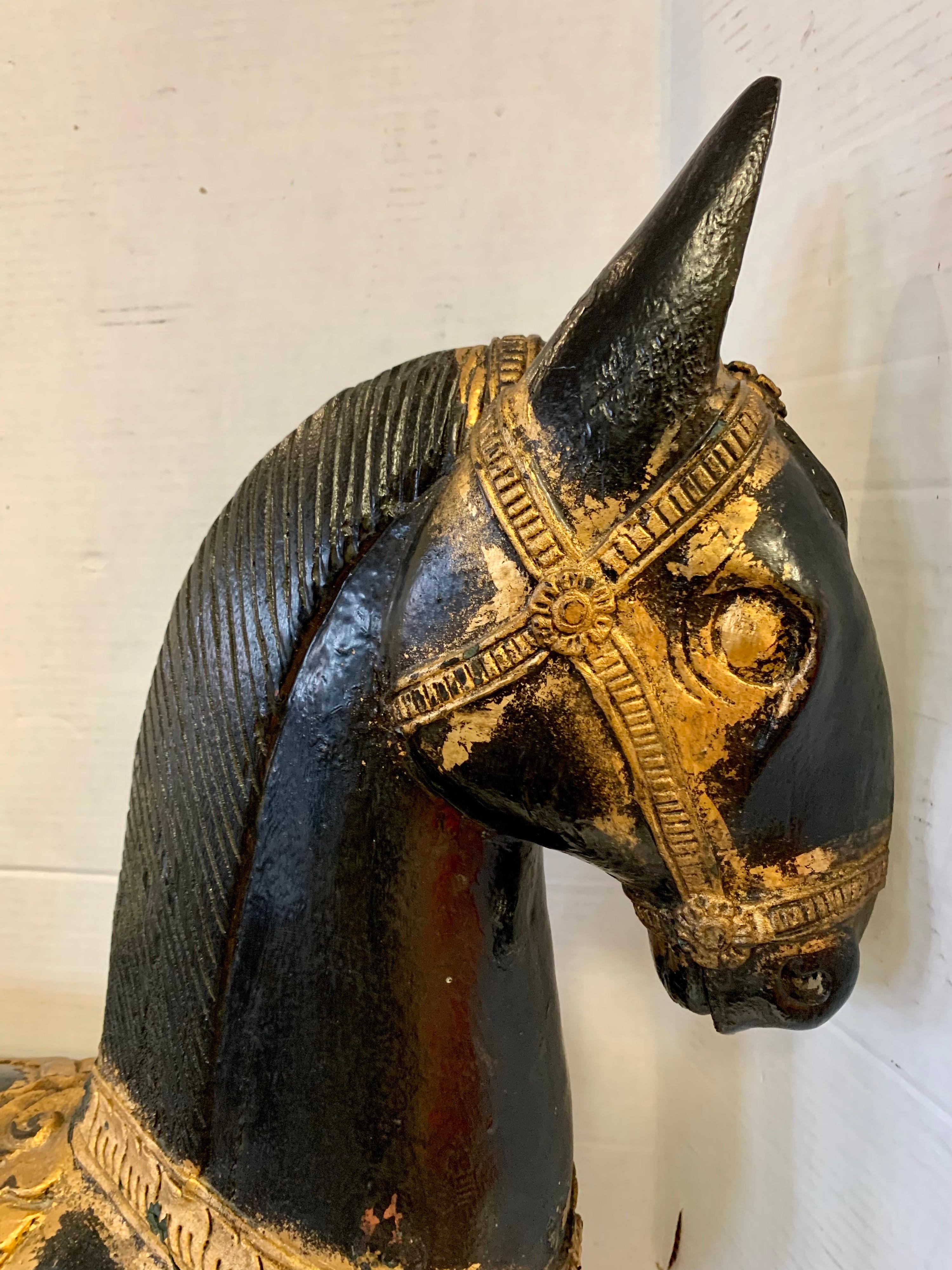 Rare 19th century carved polychrome black horse with painted gilt accents. It has a gorgeous patina only acquired via age. It has some age appropriate wear given its age which includes paint loss and a crack in the neck. None of the wear takes away