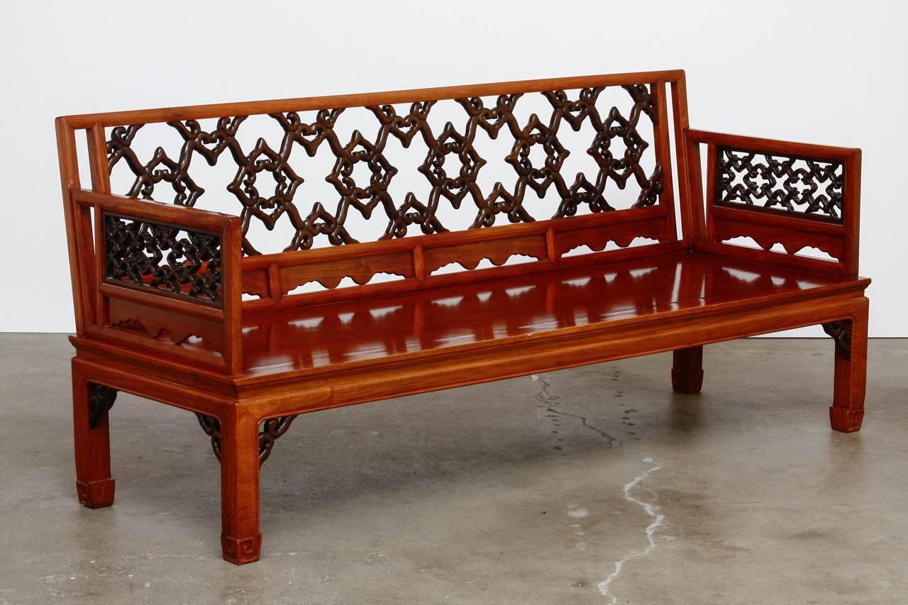 Magnificent Chinese carved daybed or bench. Constructed from radiant grain Huali rosewood. Intricate pierced open fretwork design on the back and arms featuring the highest level of craftsmanship. The floating seat is supported by square legs with