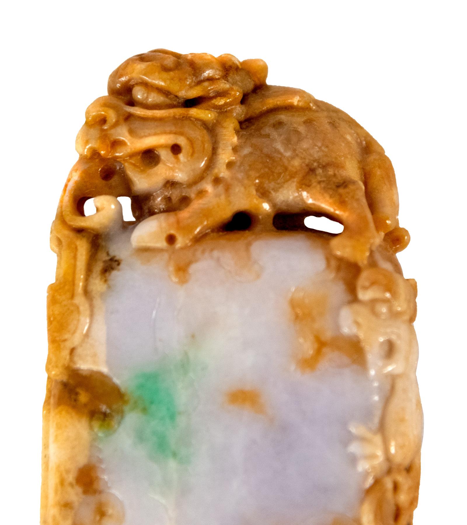 The seal is of vertical rectangular form, the body carved with a dragon, and surmounted by a mythical beast. The jade is russet color surrounding a white field with patches of apple green.