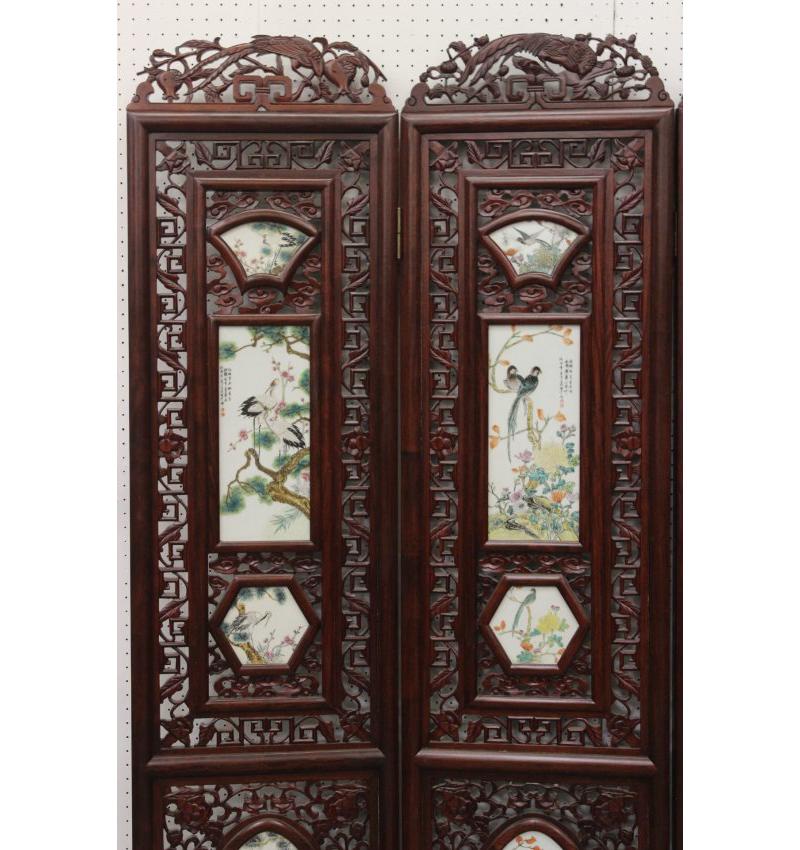 Fine Chinese carved screen with porcelain plaques. The beautiful wood is finely carved with foliage and scroll motif fretwork centered by various hand painted plaques portraying still-life natural scenes with birds.
Several plaques are inscribed in