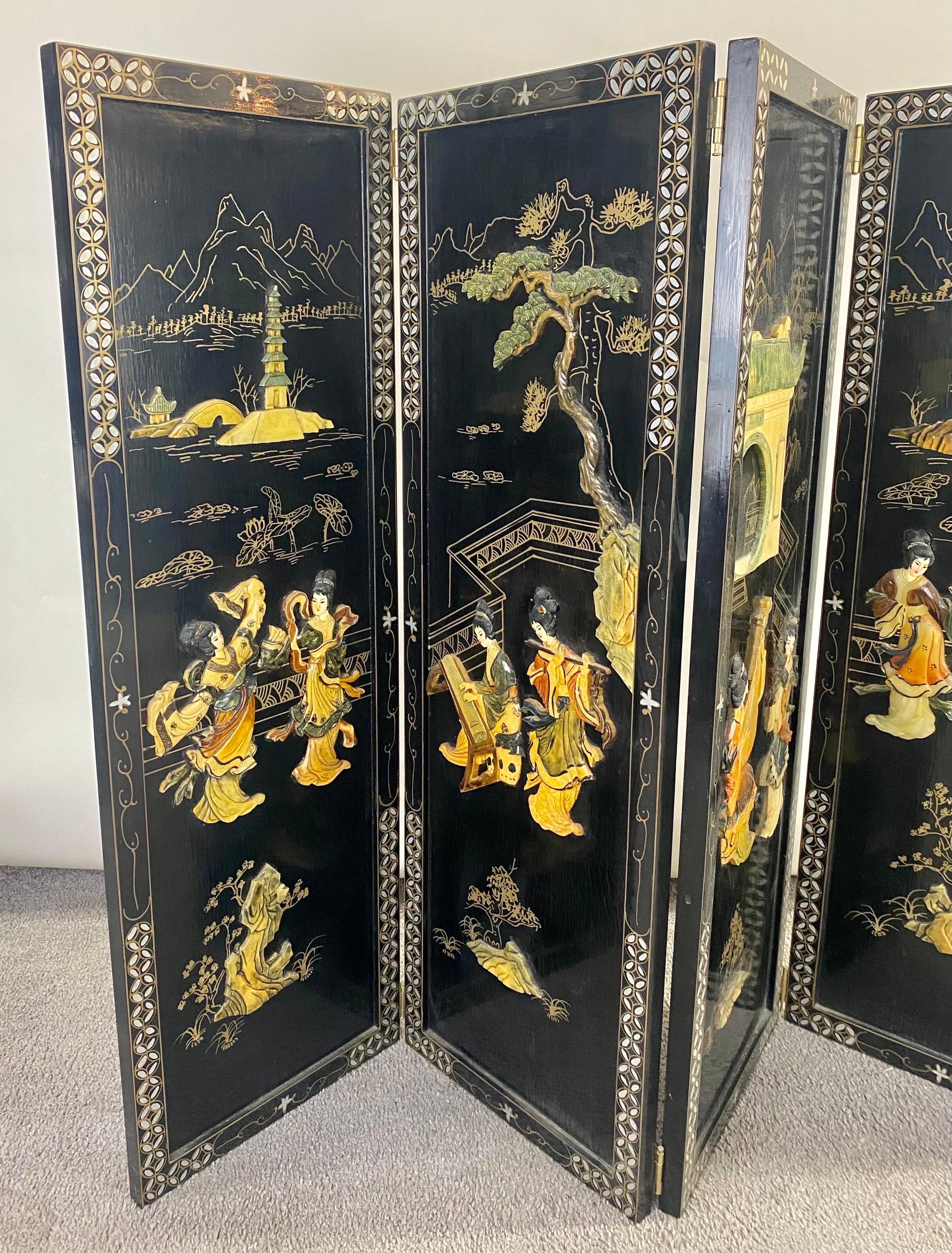 An exquisite vintage Chinese four panels decorative wall panel or screen.  The beautiful wall panel or screen depicts Chinese scenes of Gaisha girls dancing as well as gardens scenic views finely carved of soapstone and hand-painted on a black