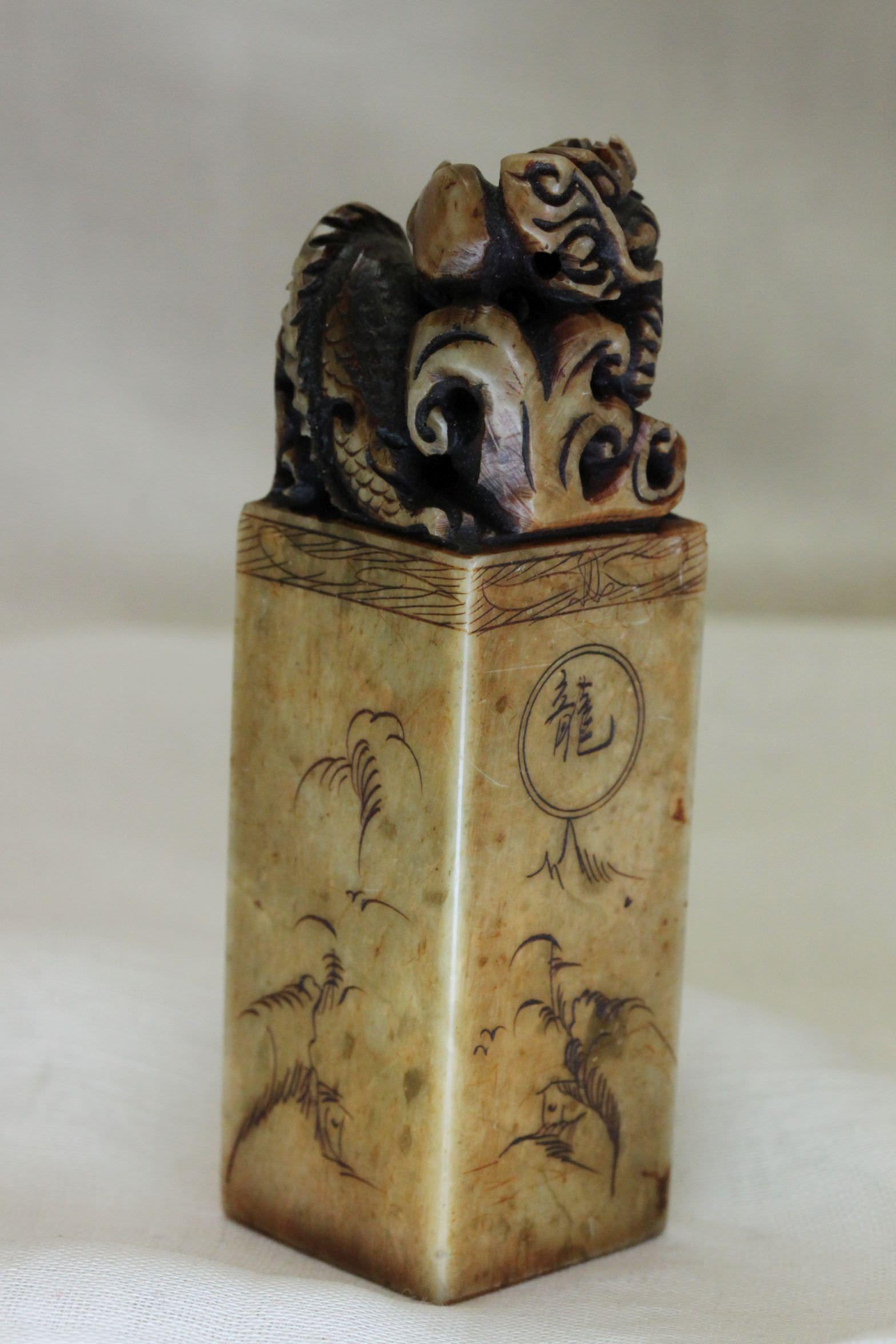 A nicely carved dragon with a pearl sits atop this Chinese soapstone seal, with the areas under the dragon decorated as well. The base carries the original owner's mark. It stands 85 mm (3 3/8ths inches) high and measures 24 mm ( 1 inch) square. It