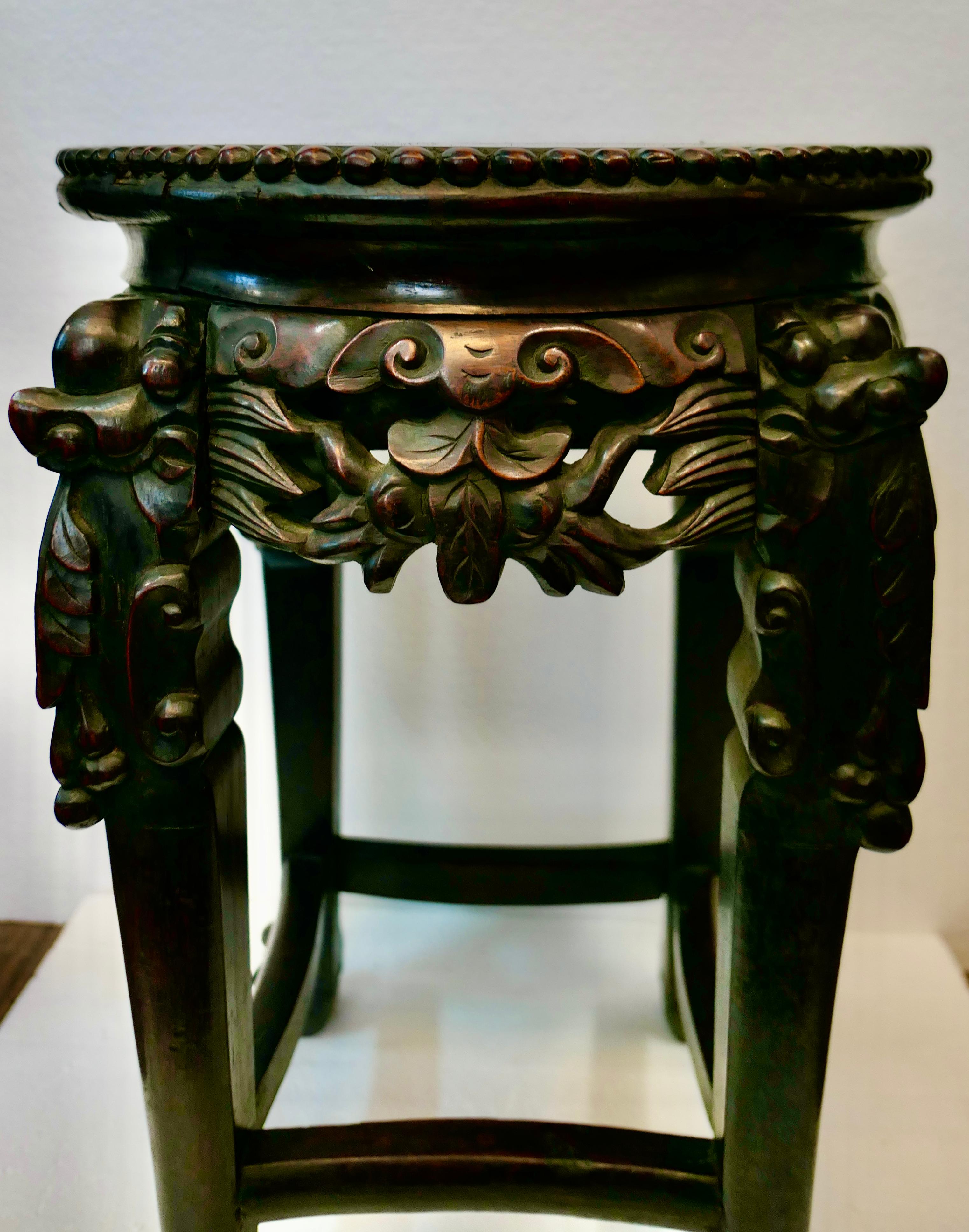 This vintage early 1900’s Chinese teak table is beautifully hand carved & superbly designed with four alternating carved apron panels & legs. These legs have a bold decorative motif accented with ball & claw feet. Four connecting braces support