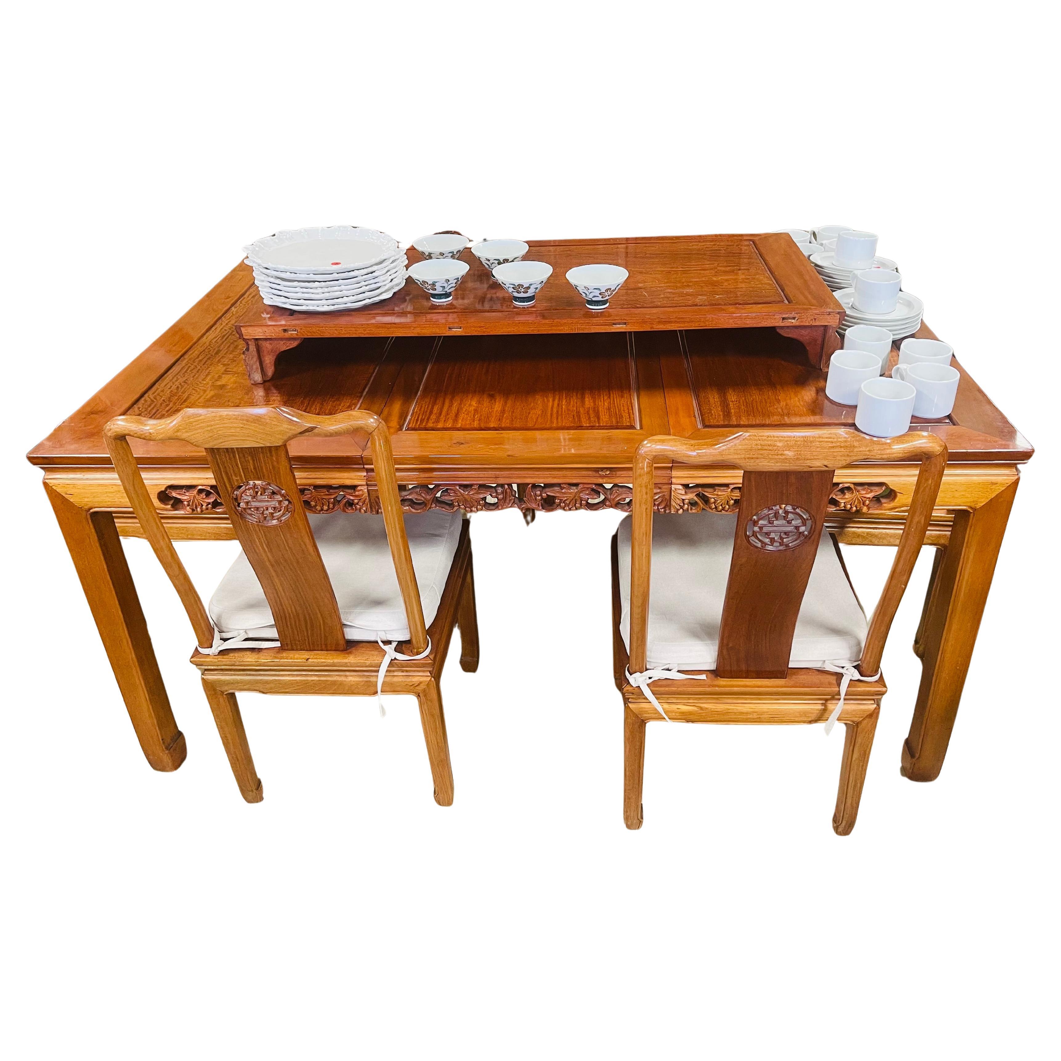 Spectaculaire ensemble de salle à manger chinois composé d'une table extensible, de 4 chaises d'appoint et de 2 fauteuils. Avec des sculptures élaborées sur les côtés du tablier et un symbole de longévité sur le dossier de la chaise. Belle couleur