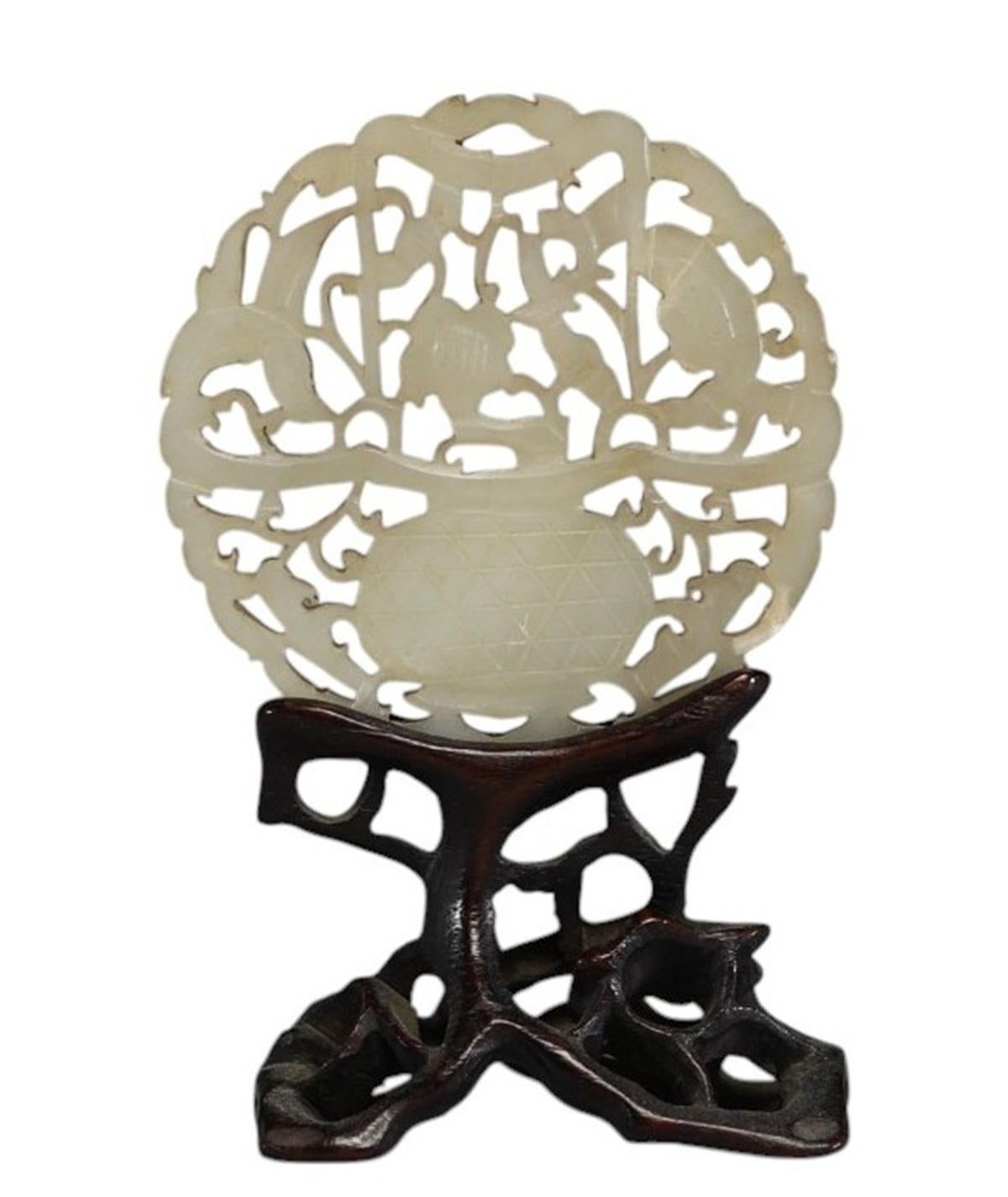 Antique 19th century Chinese disc carved in white jade on its original carved wooden base. 
Qing period 
In very good condition, diameter of the jade 5.5 cm, height on base 9 cm