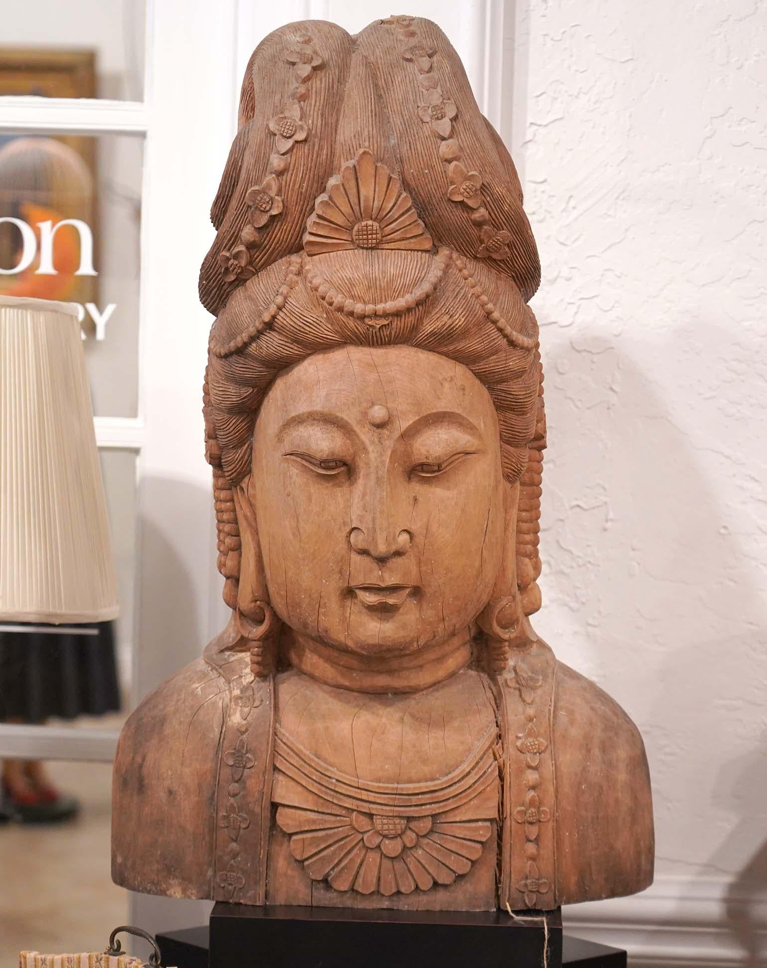 Standing 30 inches tall this carved wood sculpture of Guan Yin exudes calm and serenity. The chest, face and hair are carved with great detail, especially the downtrodden eyes are stunning.