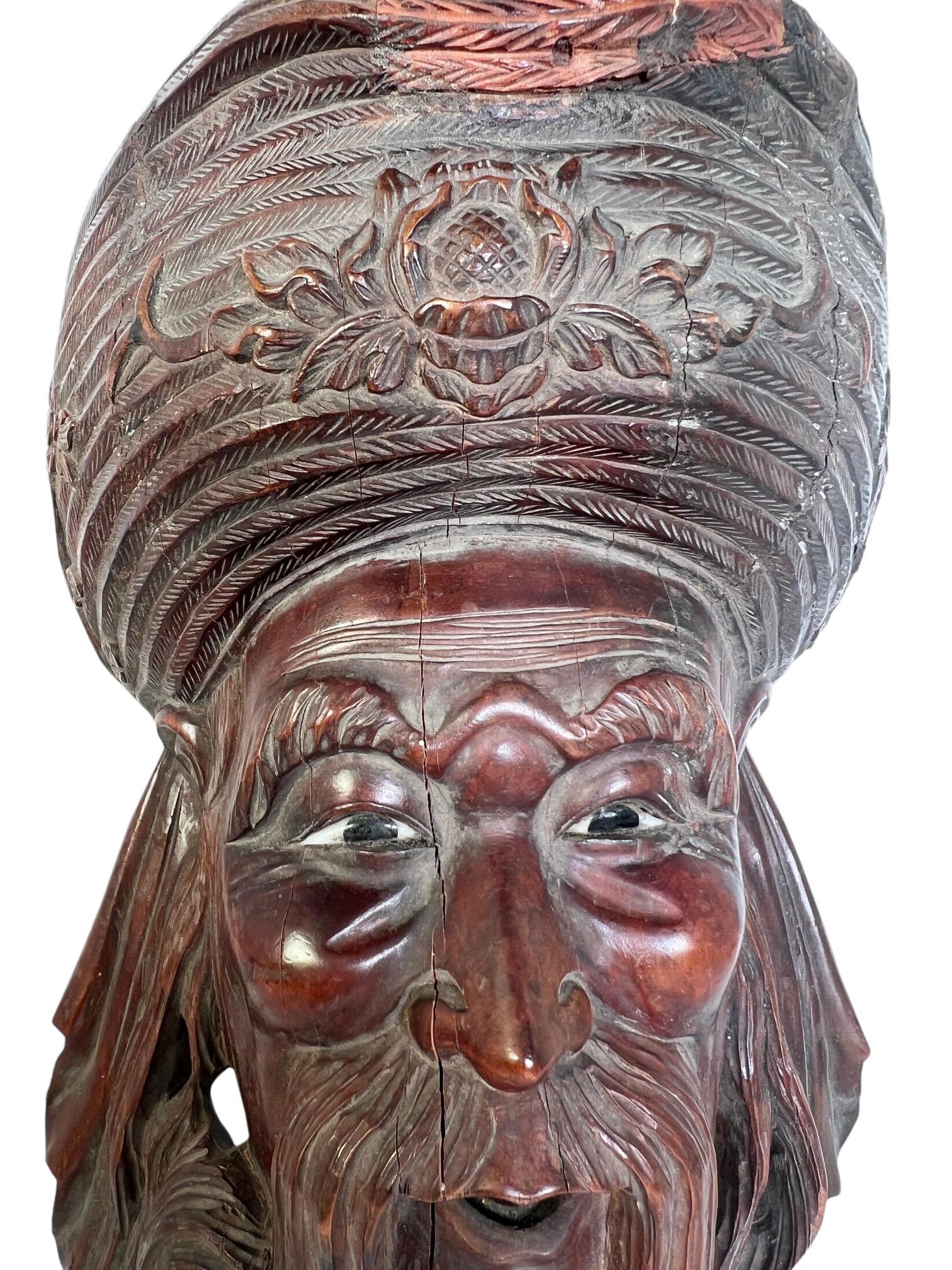 Chinese carved wood emperor with bone carved eyes. Carved wood restoration to top of hat and some splits to the wood due to age.