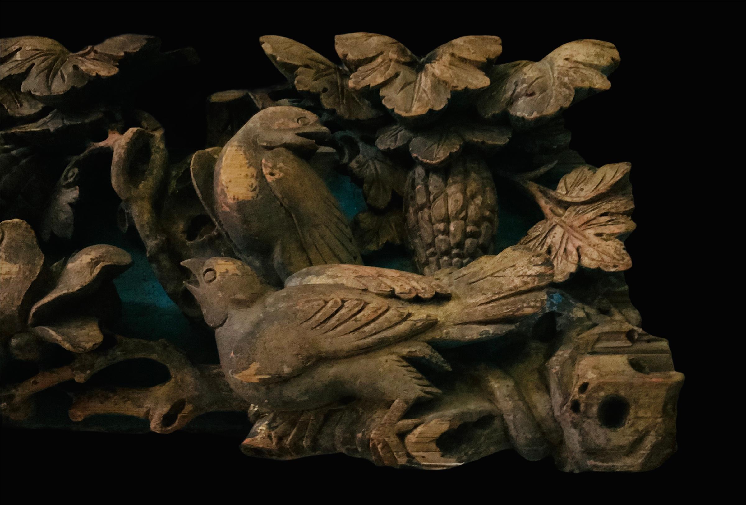 This is a chinese carved wood furniture pediment featuring a scene of two pairs of birds that appears to be doves over some oak tree branches weave with Magnolia flowers branches. One of the pair of birds are sharing a butterfly that they are