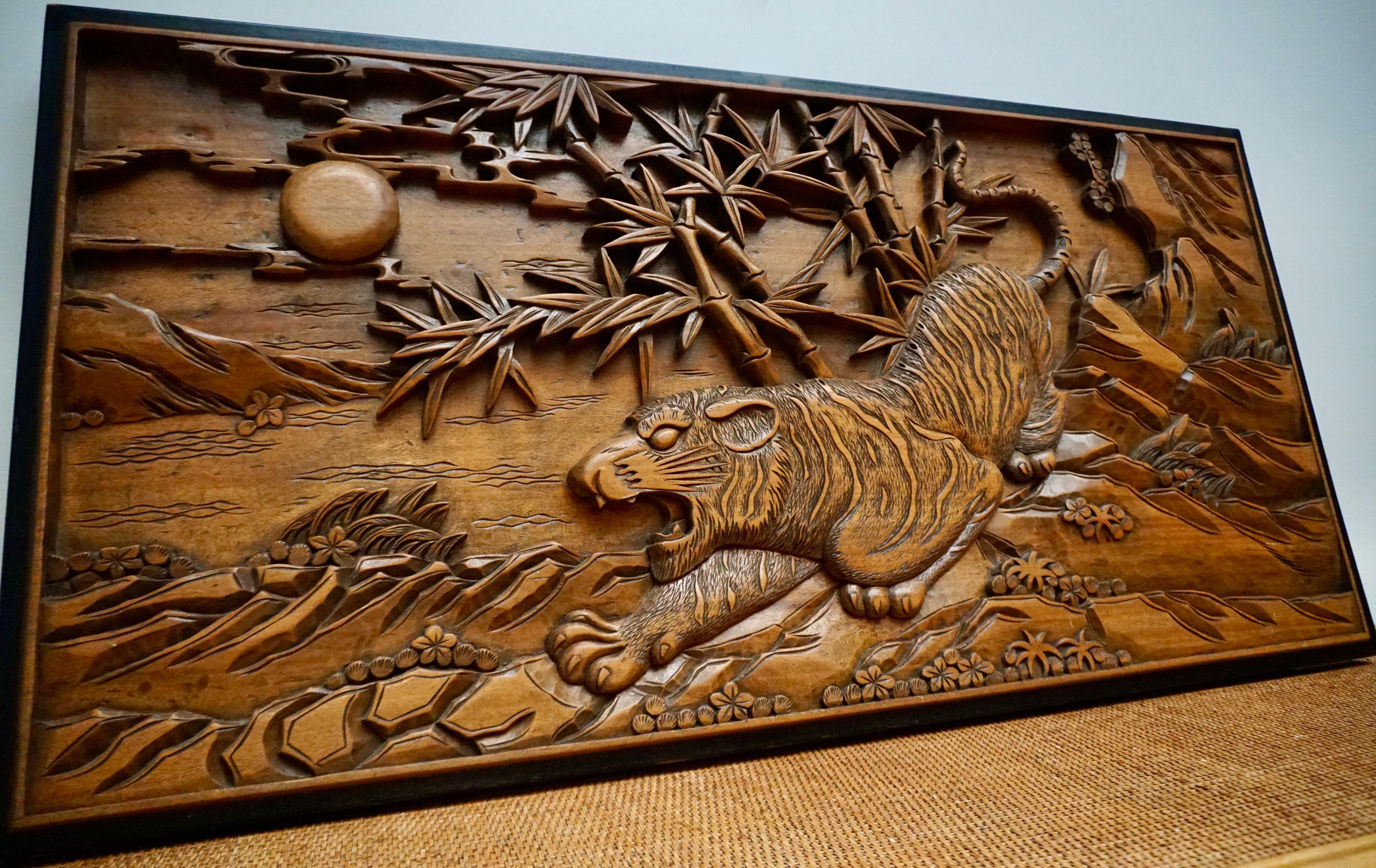 A large 19th century Chinese carved wall plaque in wood features a hunting tiger on rocks with bamboo trees and the sun in the background.
This 20th century Chinese hand carved wooden wall plaque would bring an exotic charm to any home and would